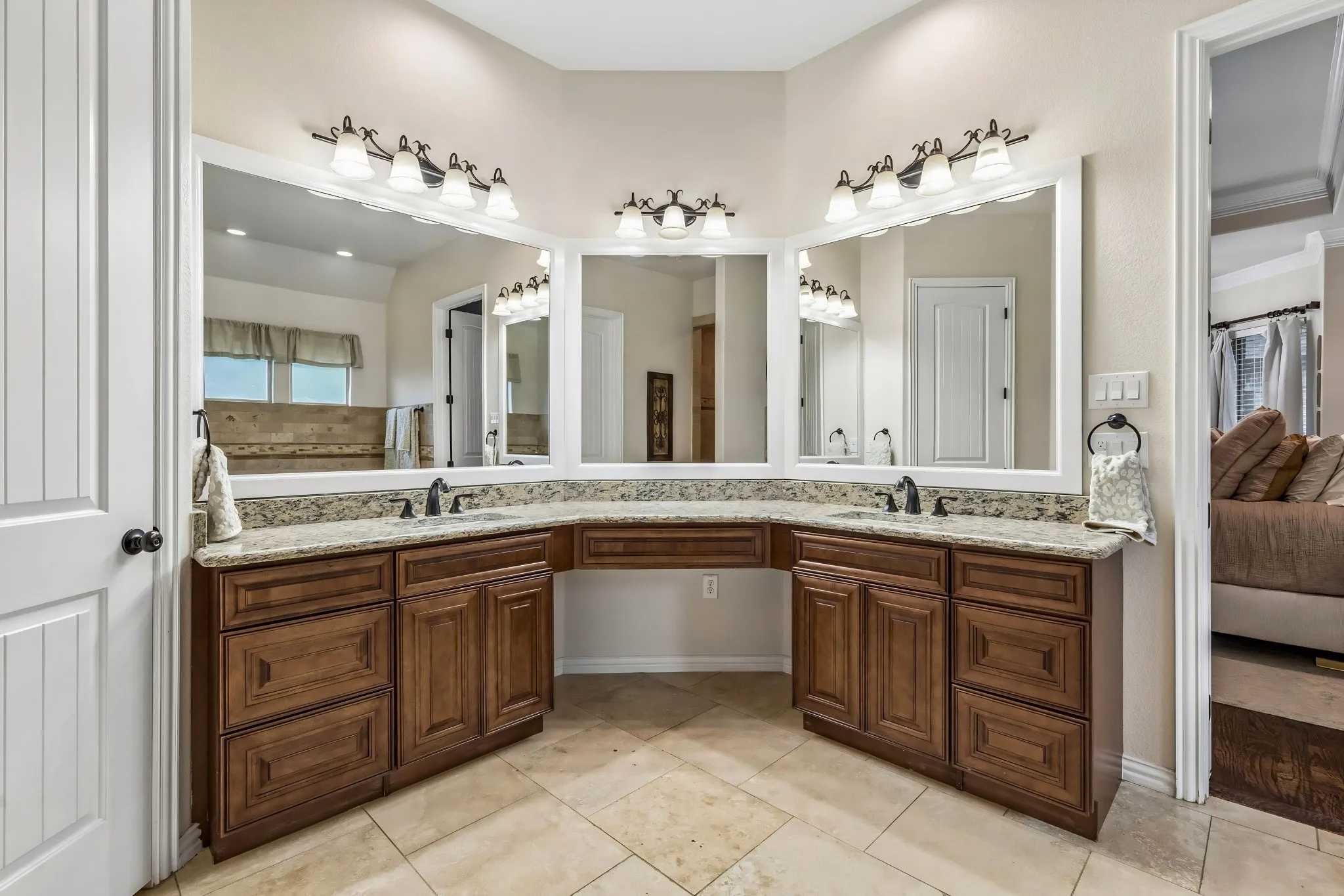 Dual wood-finish vanities with granite countertops, integrated sinks, and ample storage cabinetry