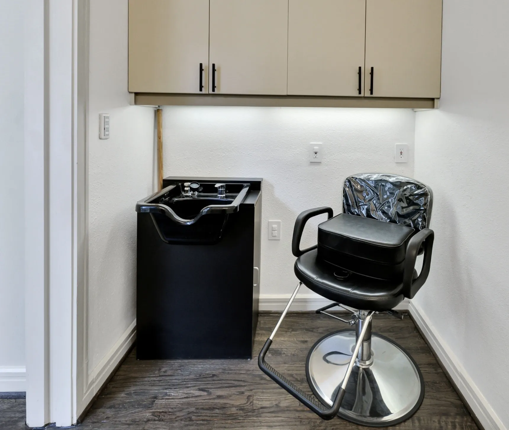 Private salon suite with professional styling chair, hair wash sink and built-in cabinetry