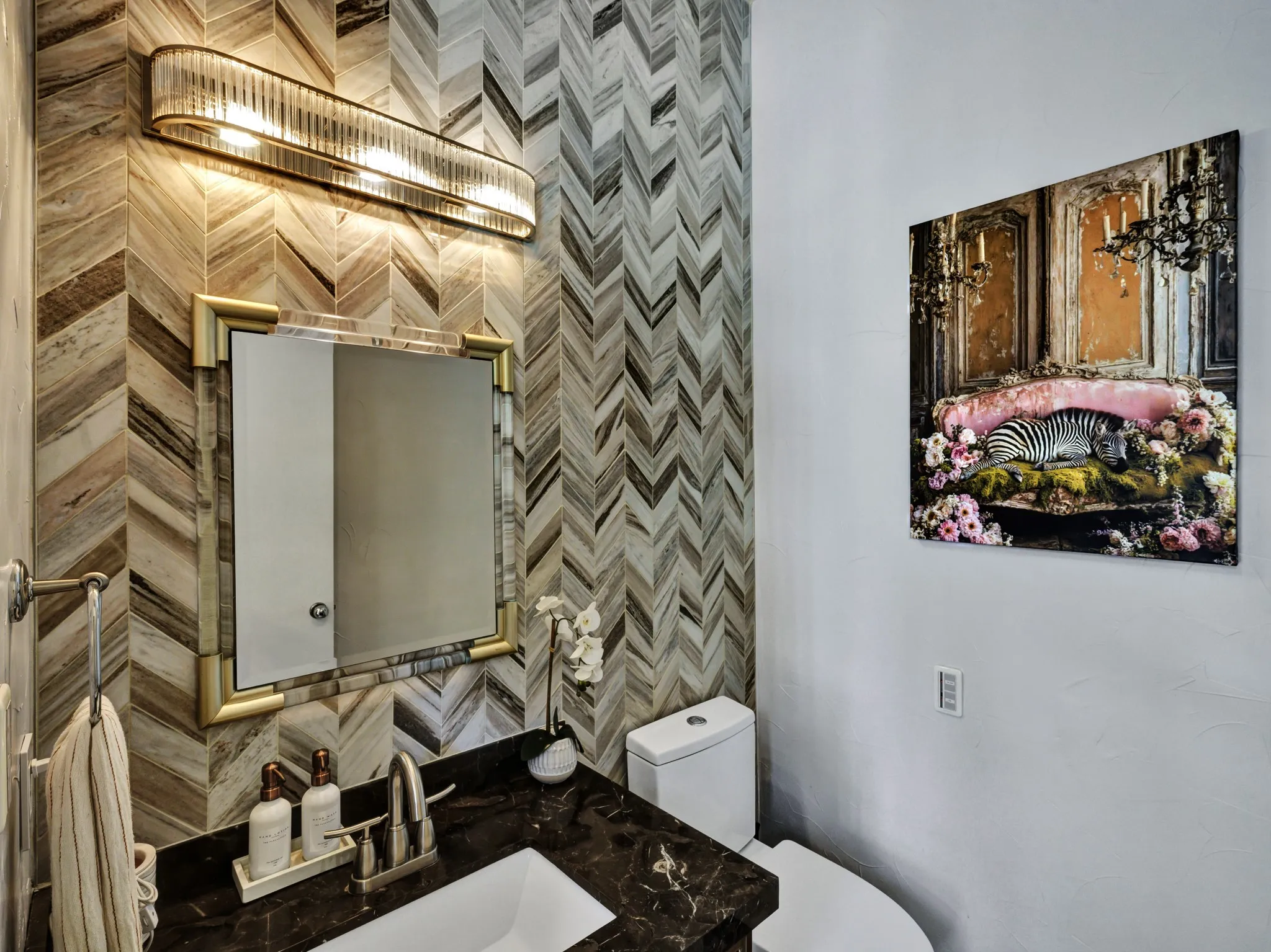 Powder room featuring a chevron-patterned tile accent wall