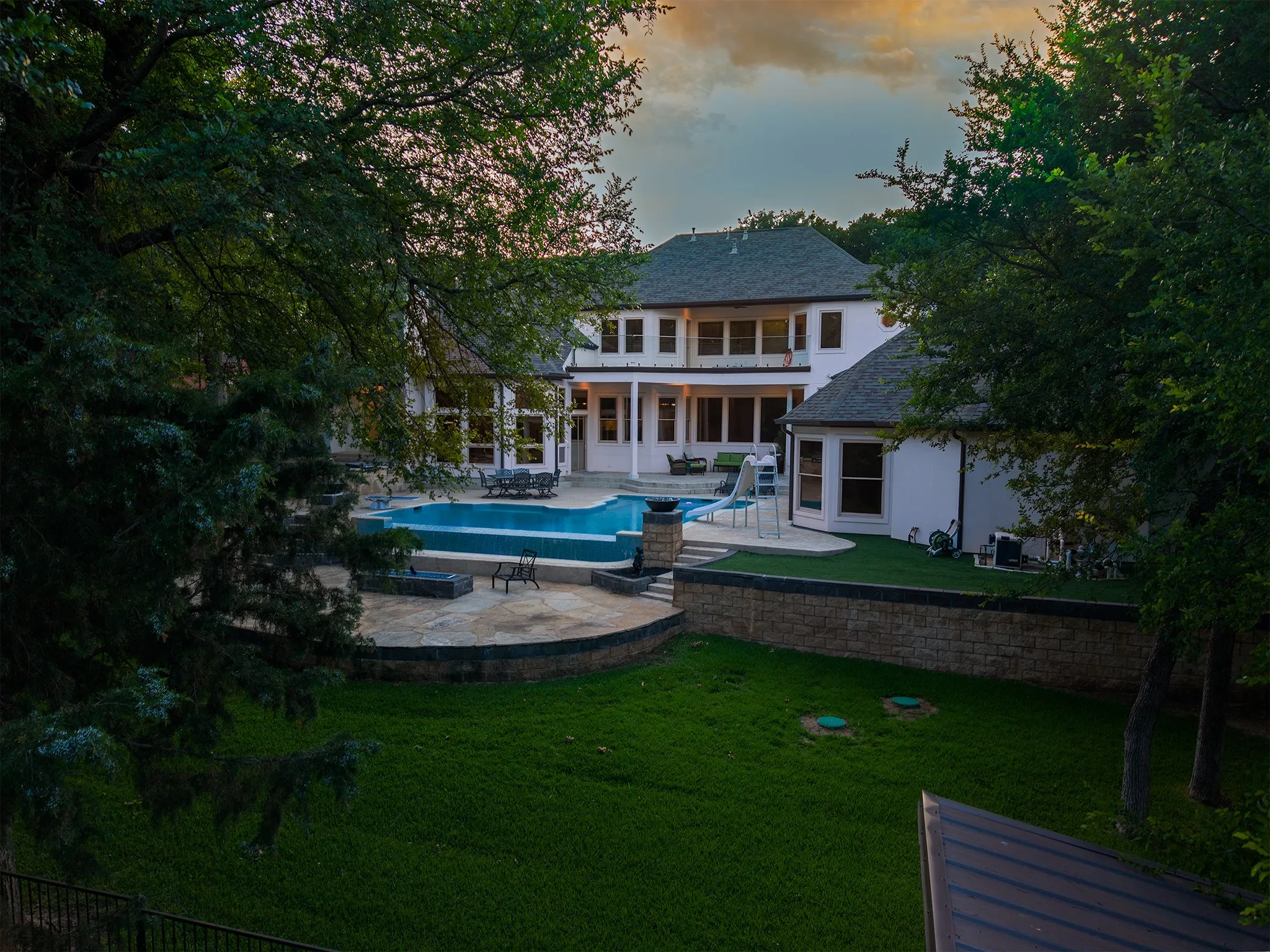 Rear exterior showcasing a multi-level design with a large swimming pool