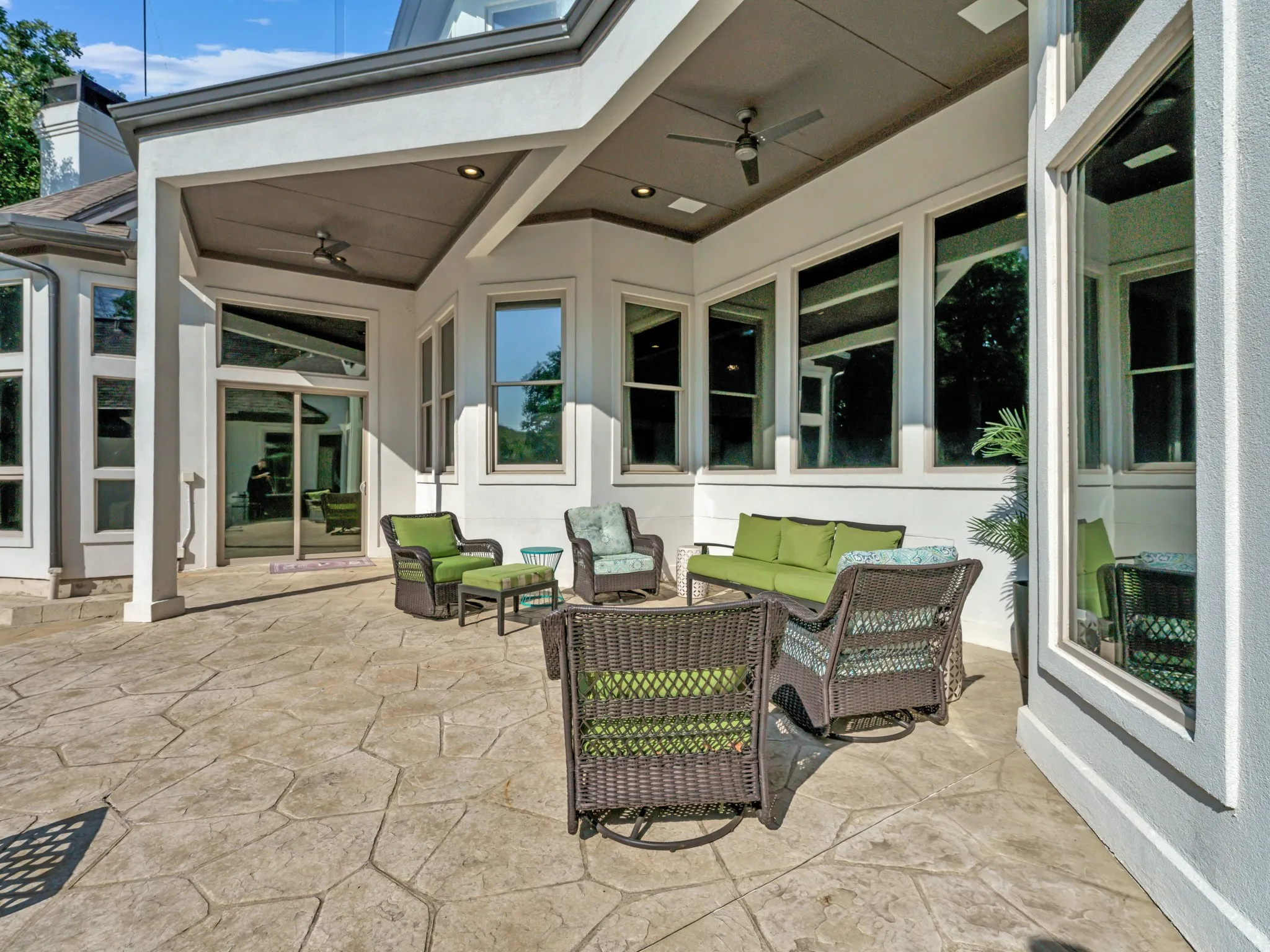 Spacious stamped concrete patio featuring a covered outdoor area with recessed lighting and ceiling fans