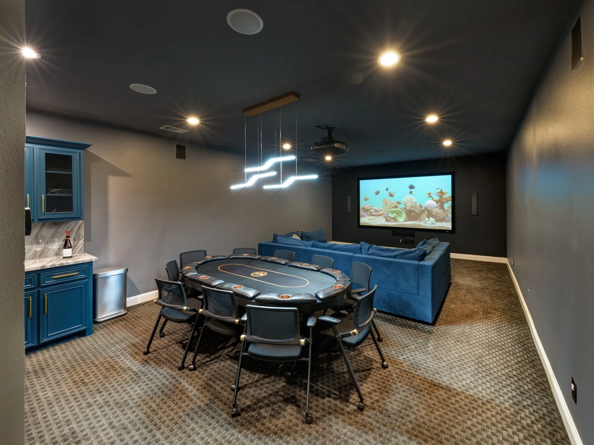 Media room featuring a large projection screen, built-in sound system, and recessed lighting
