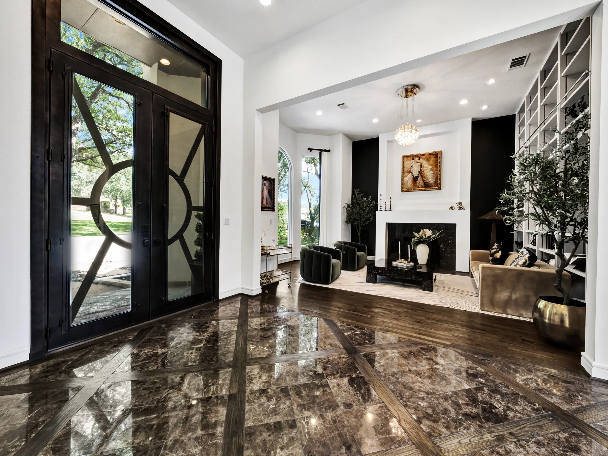 Grand entryway with custom iron and glass double doors, featuring an intricate circular design