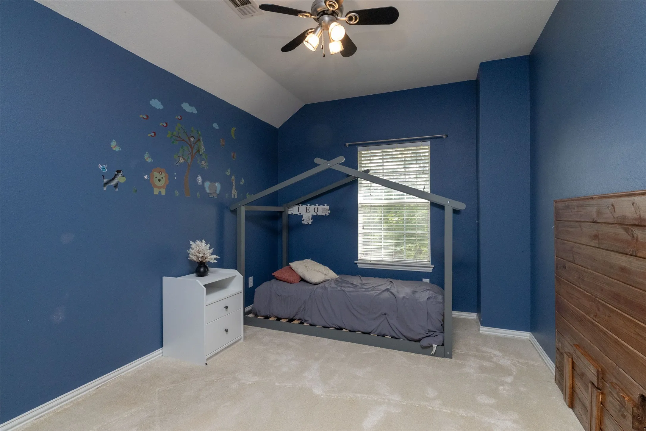 Bedroom with a vaulted ceiling, wall-to-wall carpeting, and a ceiling fan with integrated lighting