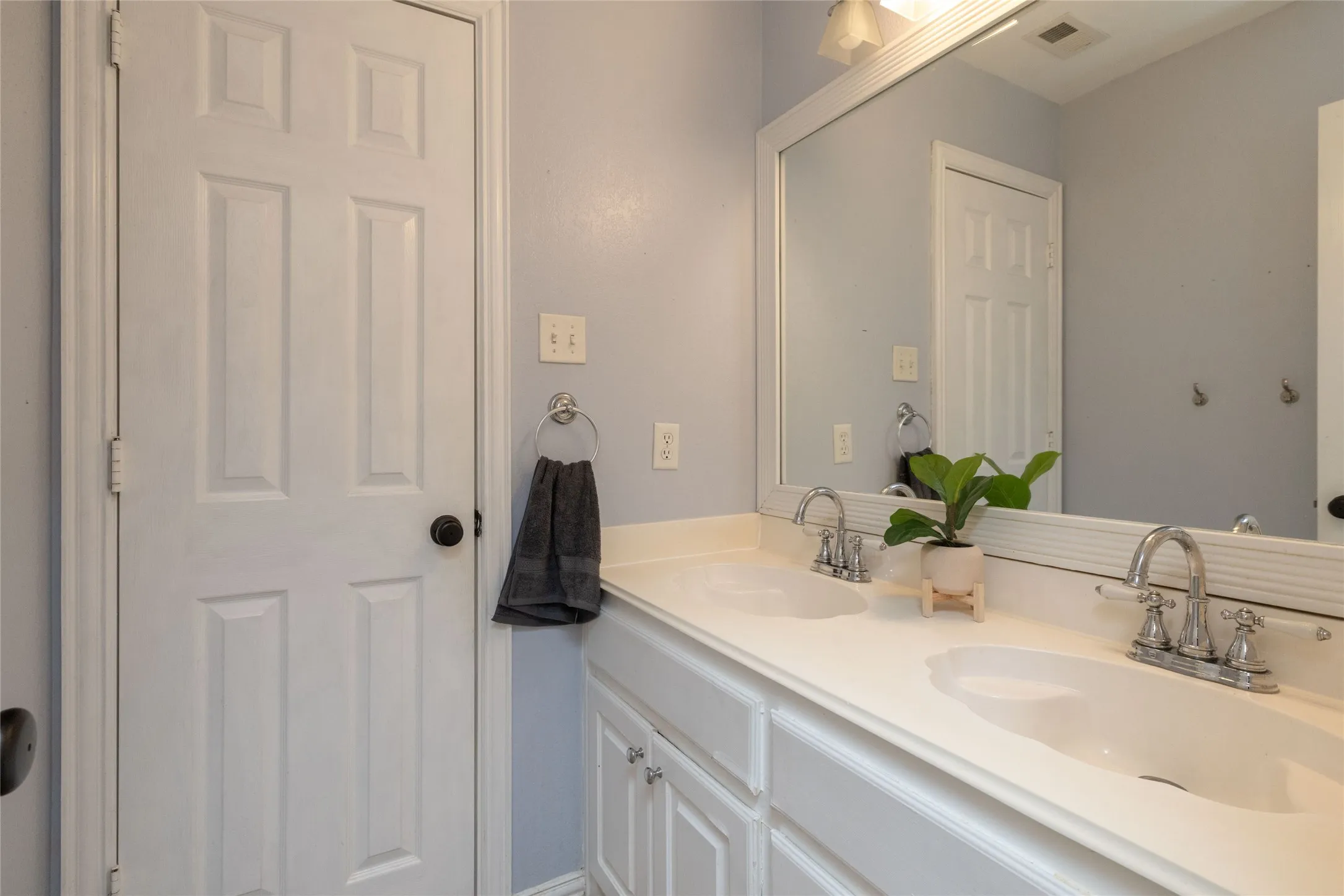 Dual vanity with integrated sinks, chrome faucets, and white cabinetry