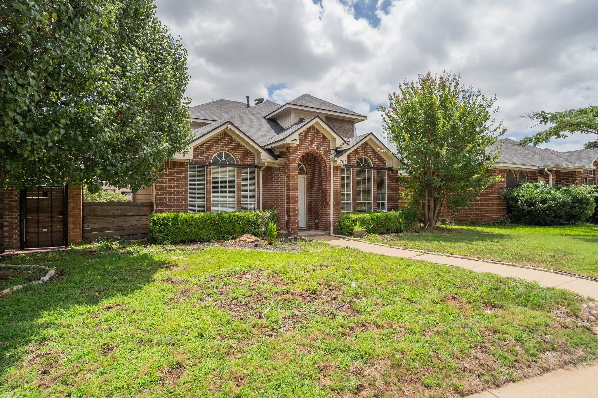 Brick exterior with multiple gables and an arched entry