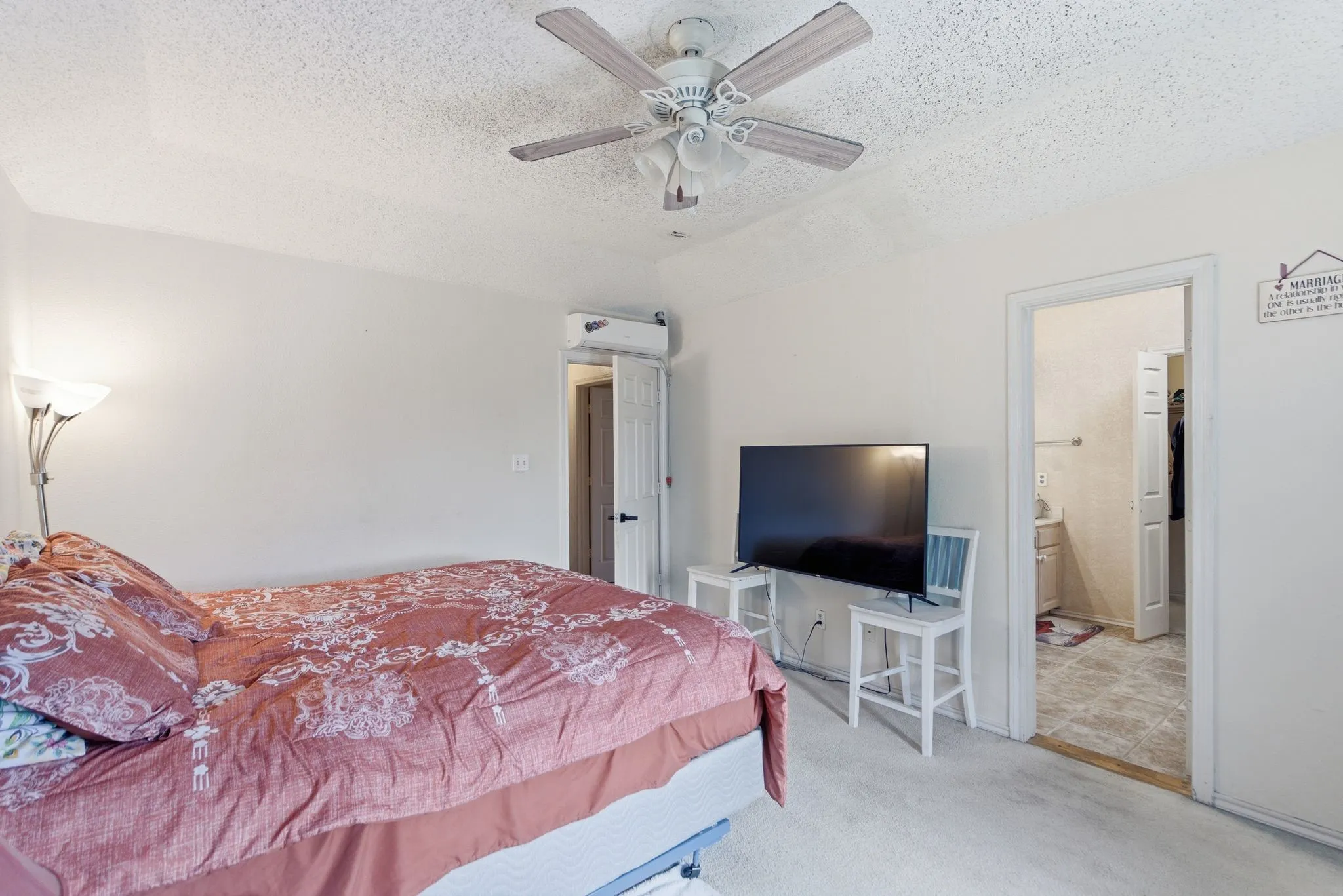 Carpeted room with a ceiling fan light fixture and white walls