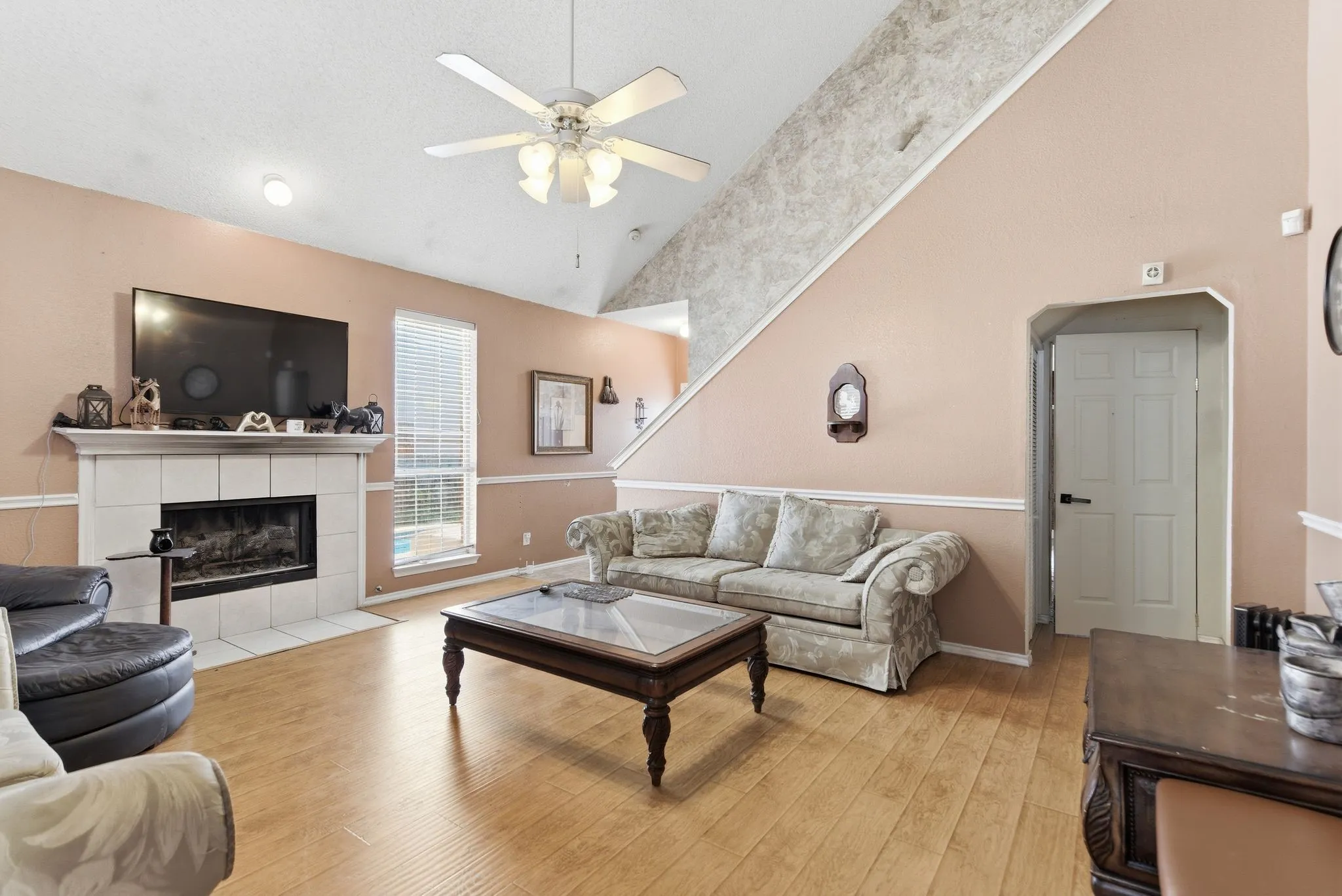 Living area featuring wood-finish flooring and a vaulted ceiling