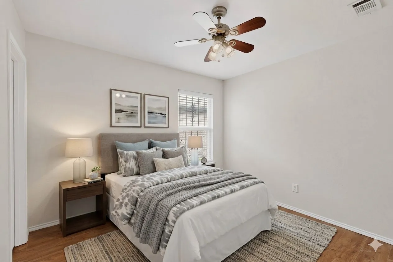 Spacious bedroom featuring wood-finish flooring, a ceiling fan with light fixture, and a window with horizontal blinds