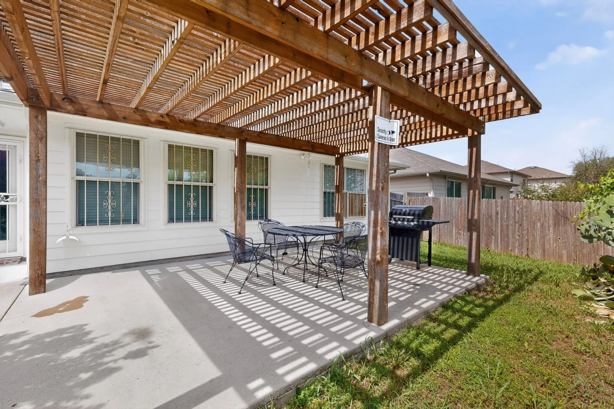 Concrete patio featuring a large wooden pergola, creating an outdoor shaded area