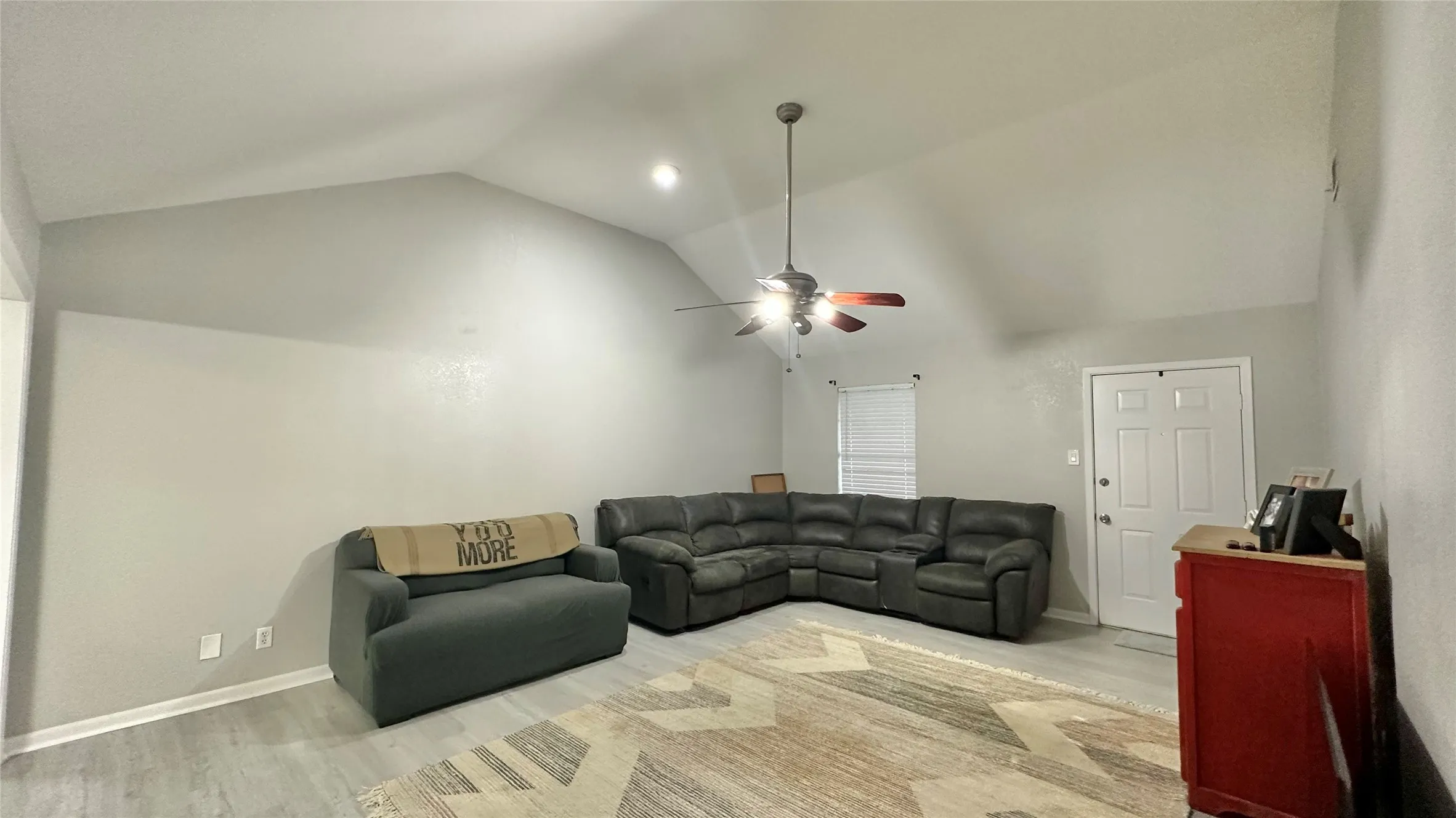 Vaulted ceiling with a ceiling fan, recessed lighting, and vinyl plank flooring