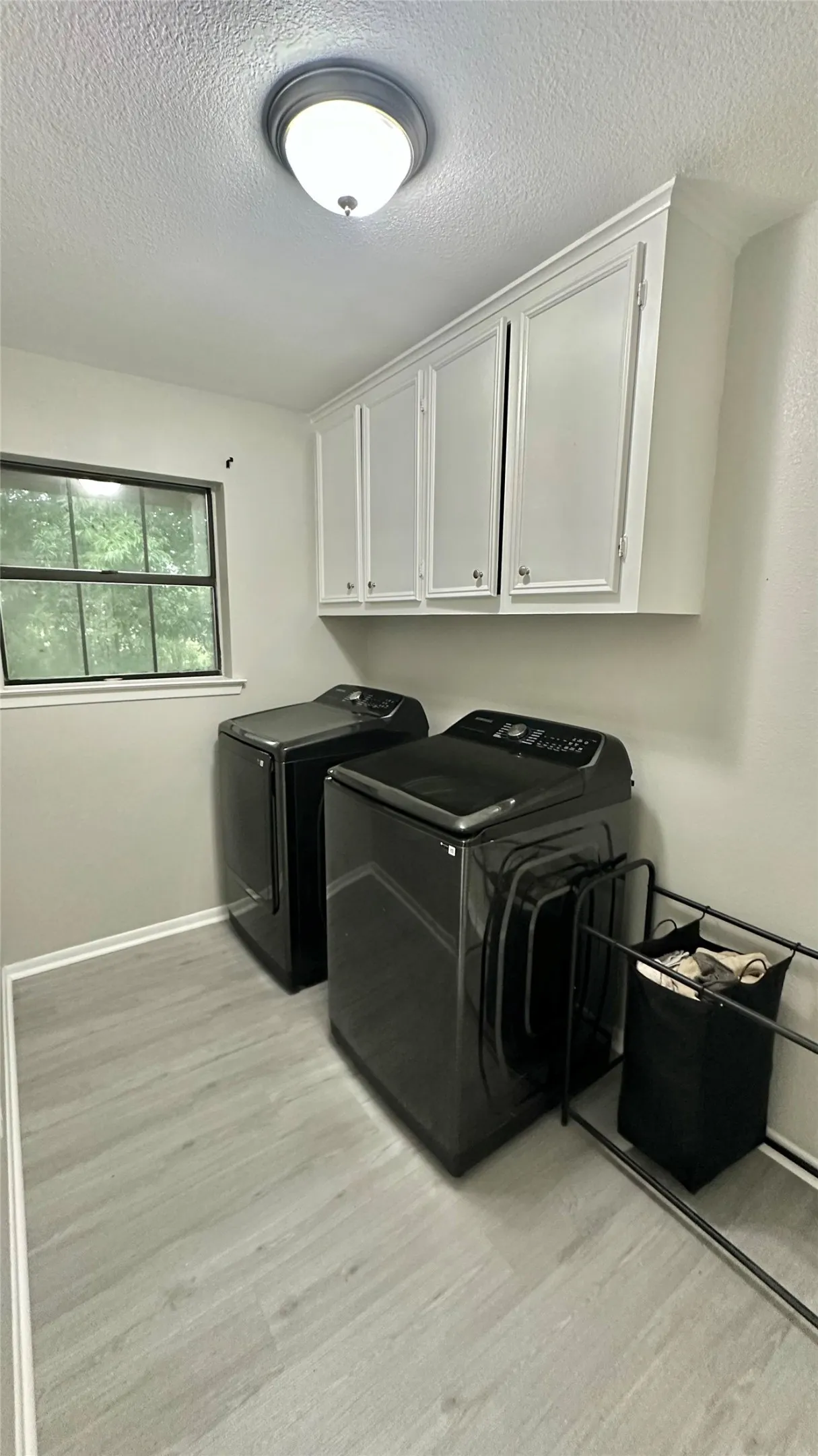 Dedicated laundry area featuring white wall cabinetry