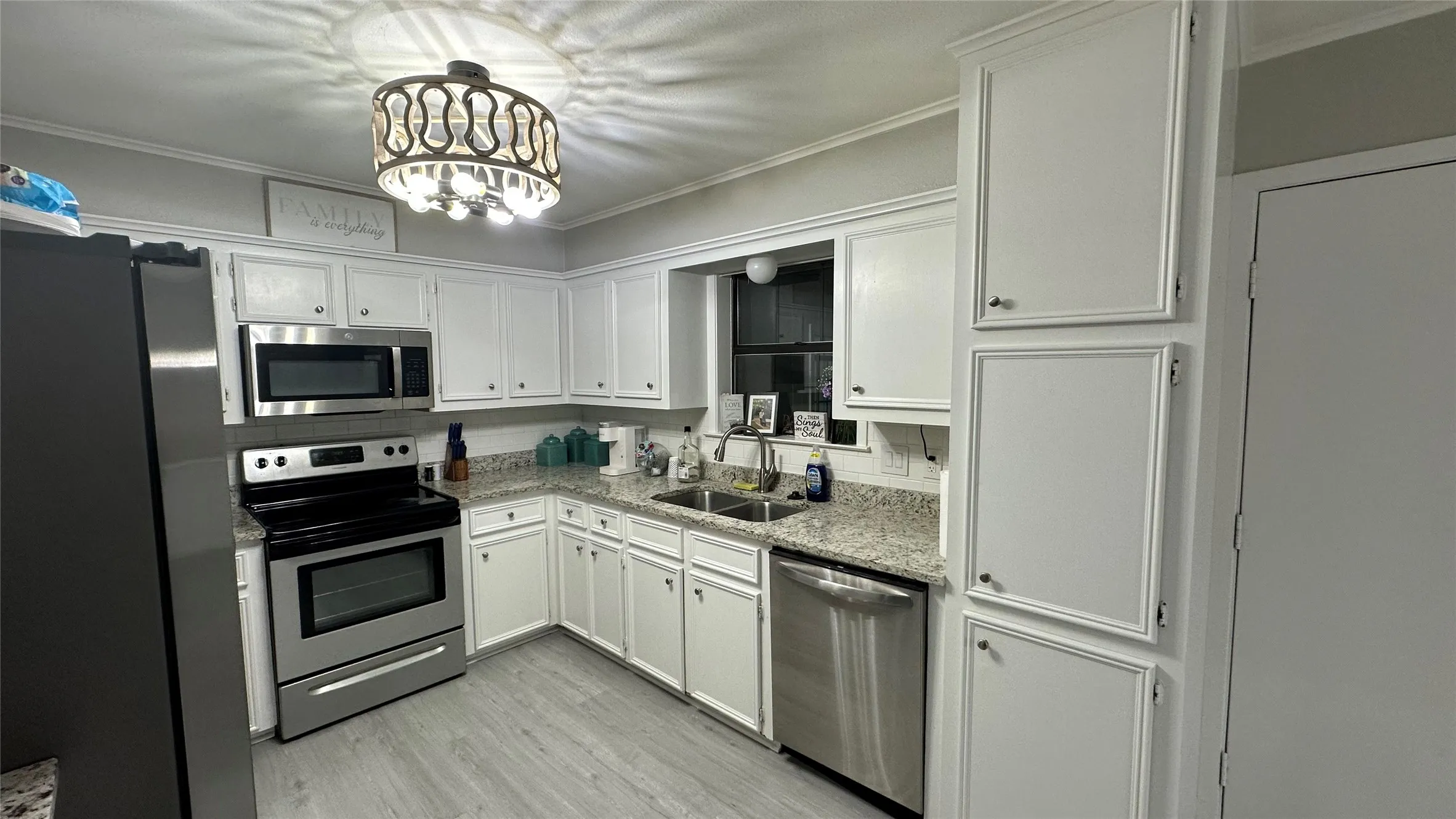 Kitchen featuring white cabinetry, light-toned granite countertops,
