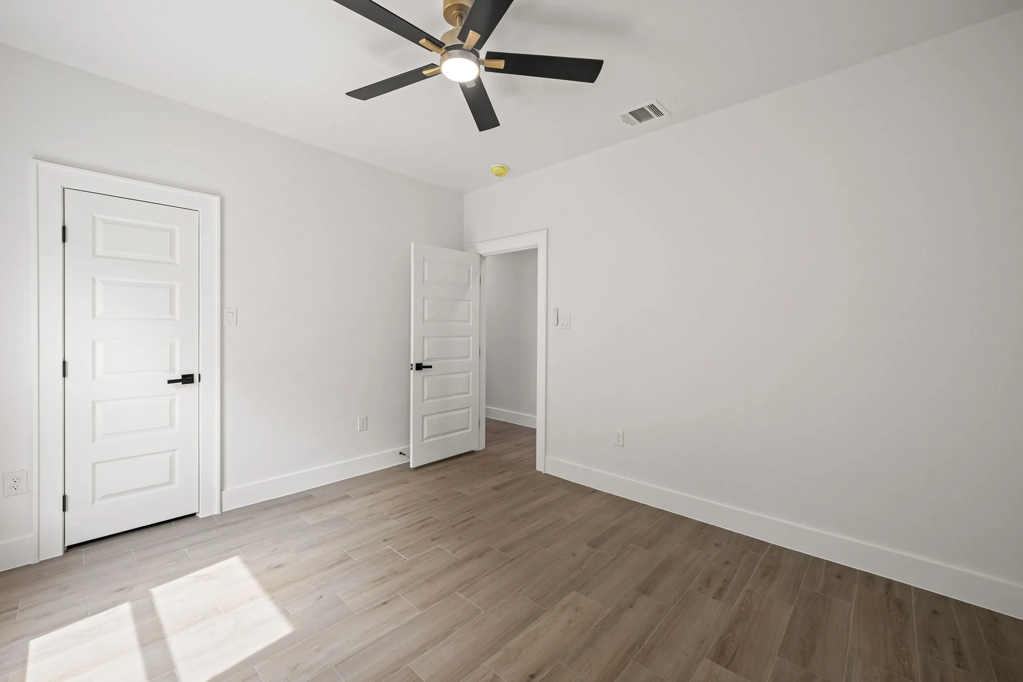 Light wood-finish flooring complements white walls with matching baseboards