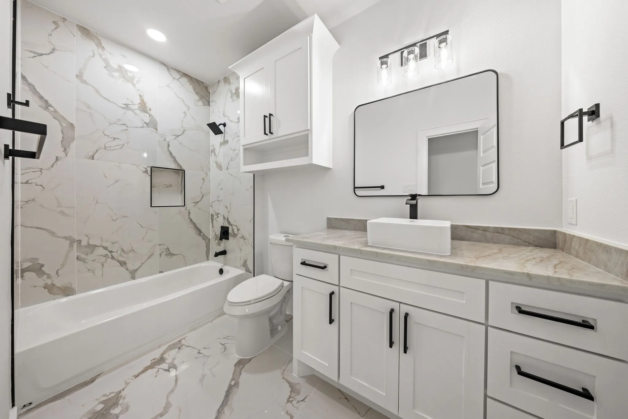 Bathroom featuring a large vanity with a rectangular vessel sink, white shaker-style cabinetry, and a light-colored countertop