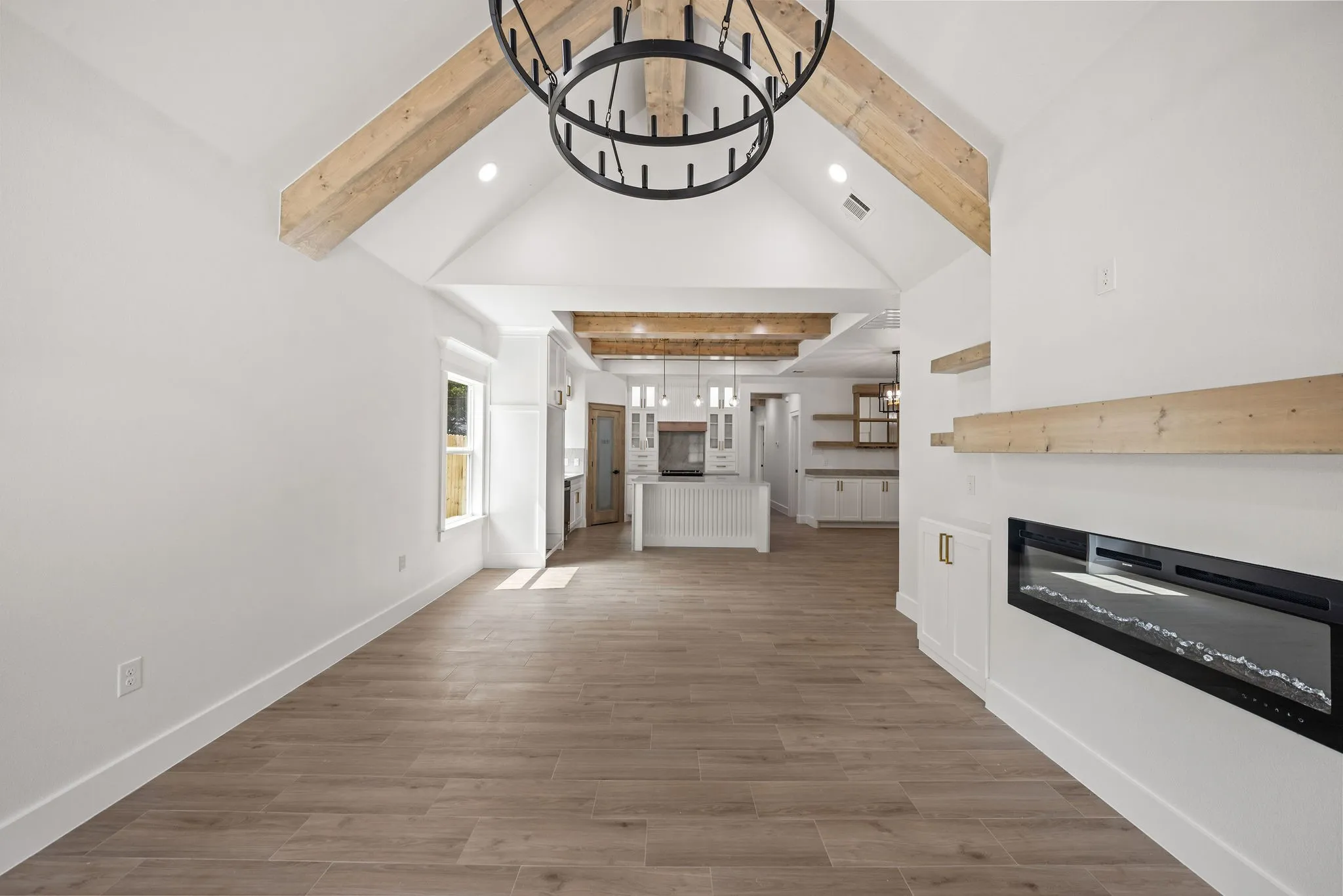 Vaulted ceiling with exposed wood beams and central chandelier