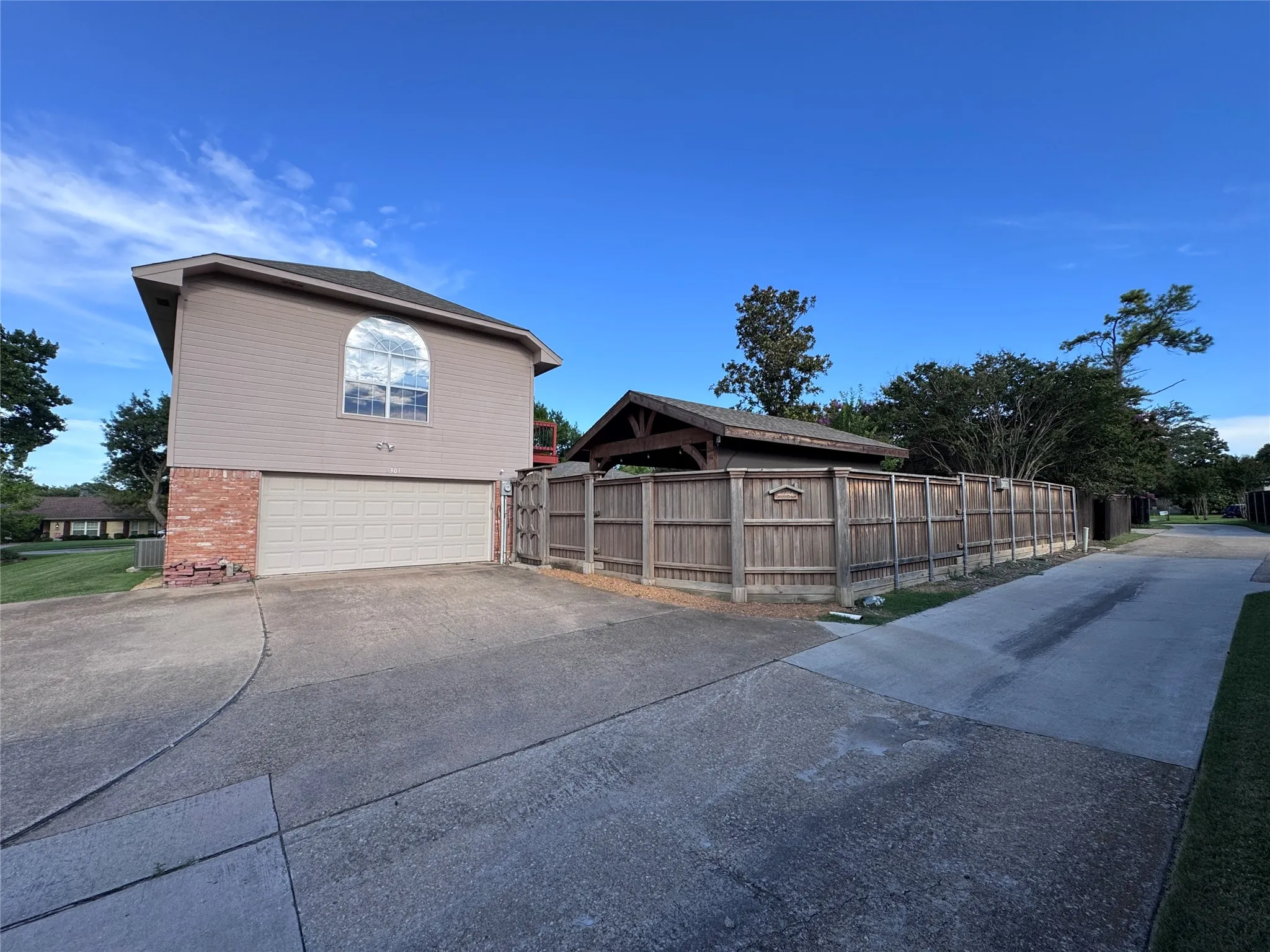 back of house with extra driveway parking