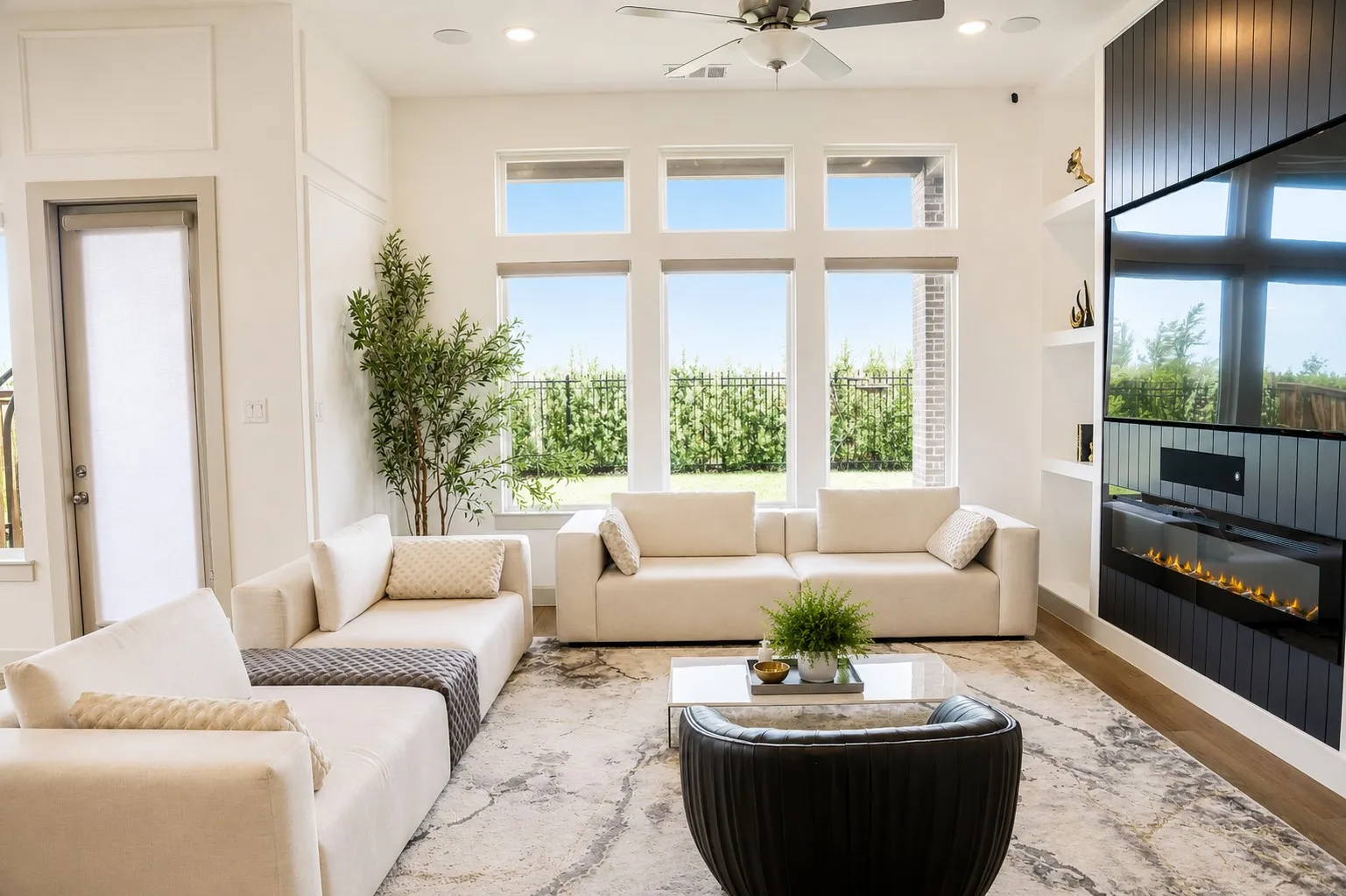 Spacious living area featuring large windows, wood-finish flooring, recessed lighting, and a ceiling fan