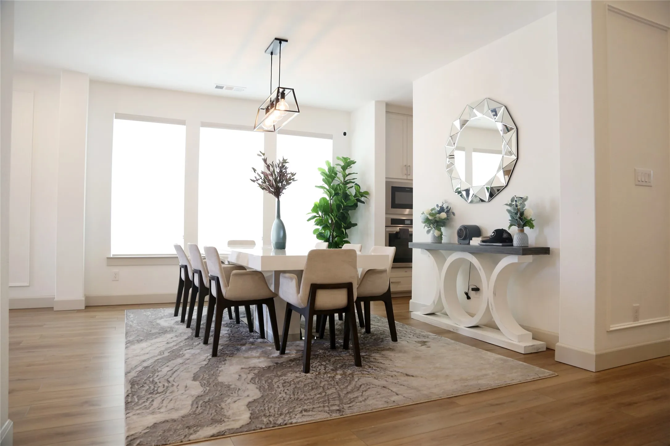 Dining area featuring wood-finish flooring, a contemporary chandelier, and large windows