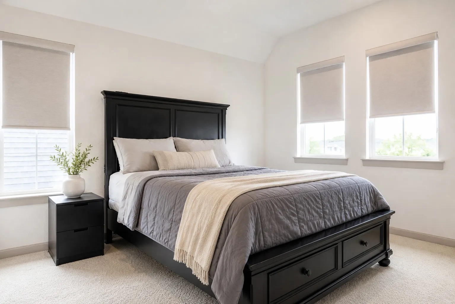 Carpeted bedroom featuring multiple windows with blinds, a vaulted ceiling, and ample natural light
