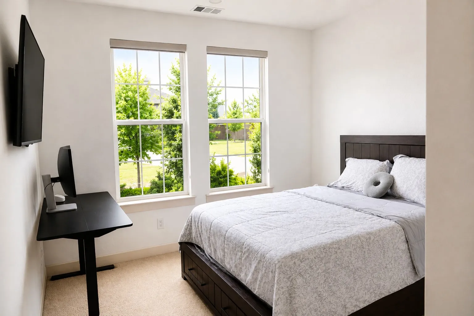 Light-filled interior featuring two large windows, neutral carpet flooring, and a ceiling vent