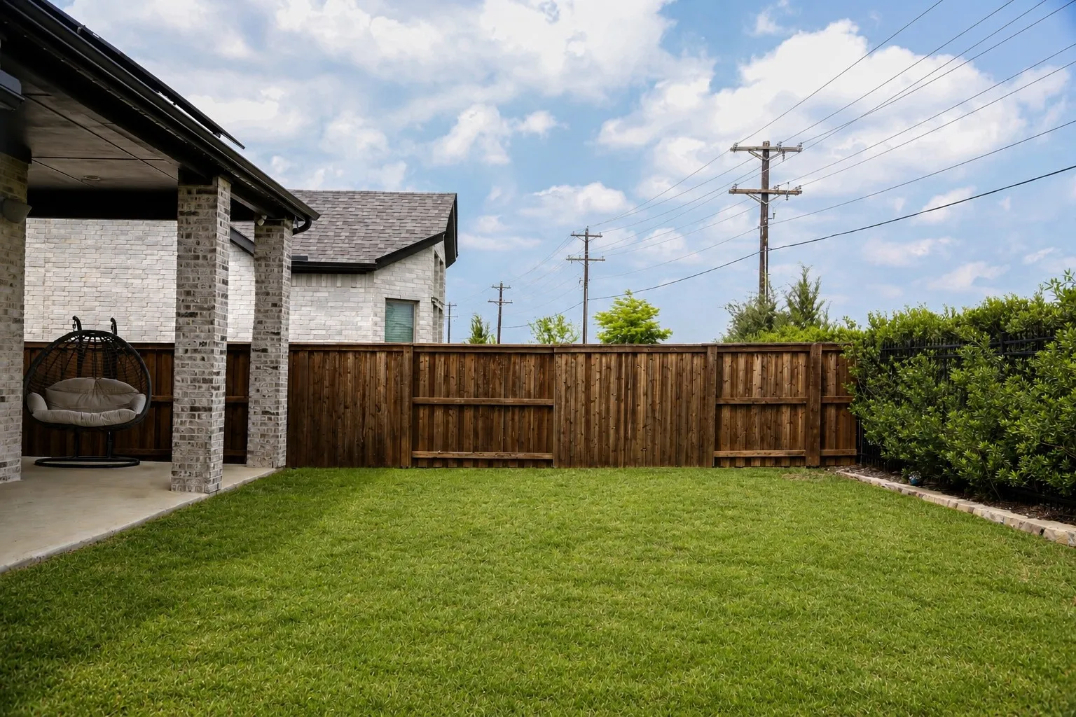 Expansive backyard featuring a lush lawn, privacy fencing, and mature perimeter landscaping