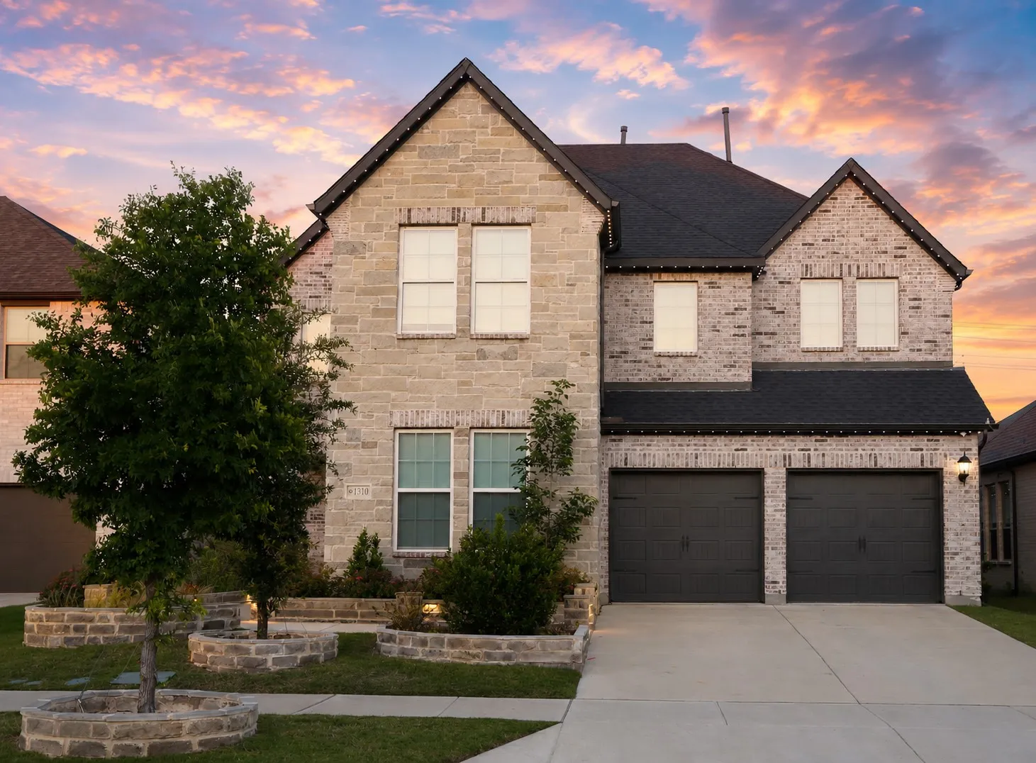Stone and brick facade residence with a two-car garage