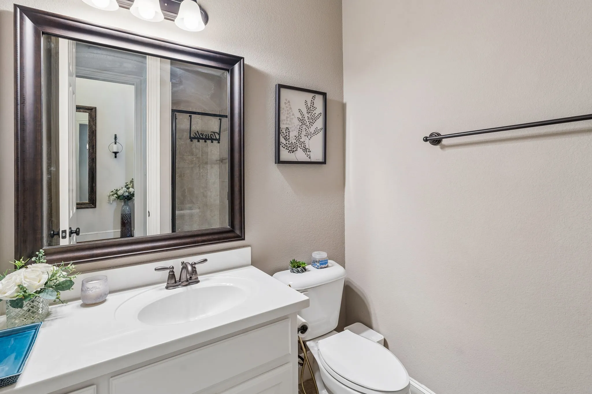Bathroom vanity with an integrated white sink, dual-handle faucet, and framed mirror
