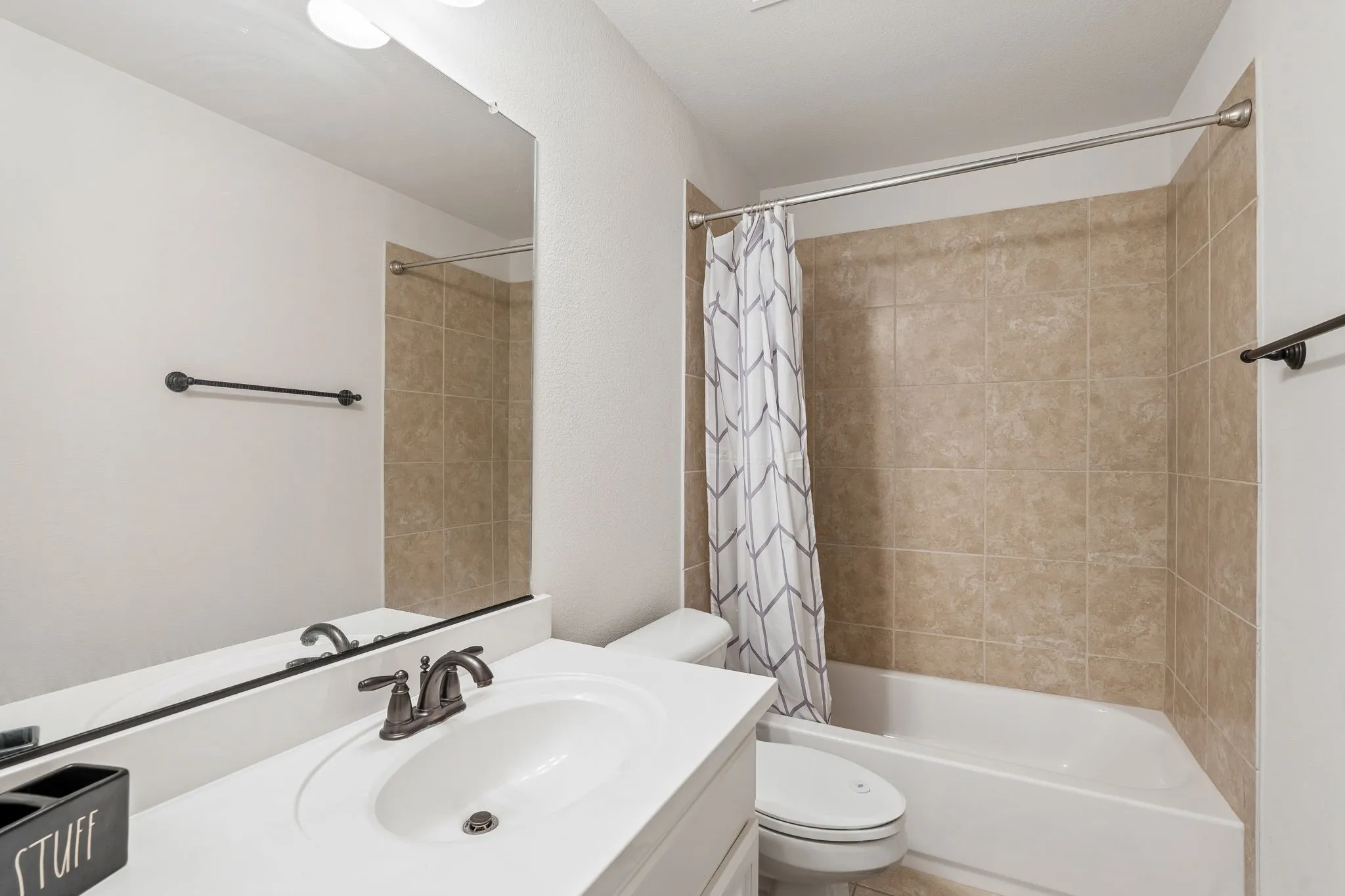 Bathroom featuring a vanity with an integrated sink, bronze-finish faucet, and an expansive wall mirror