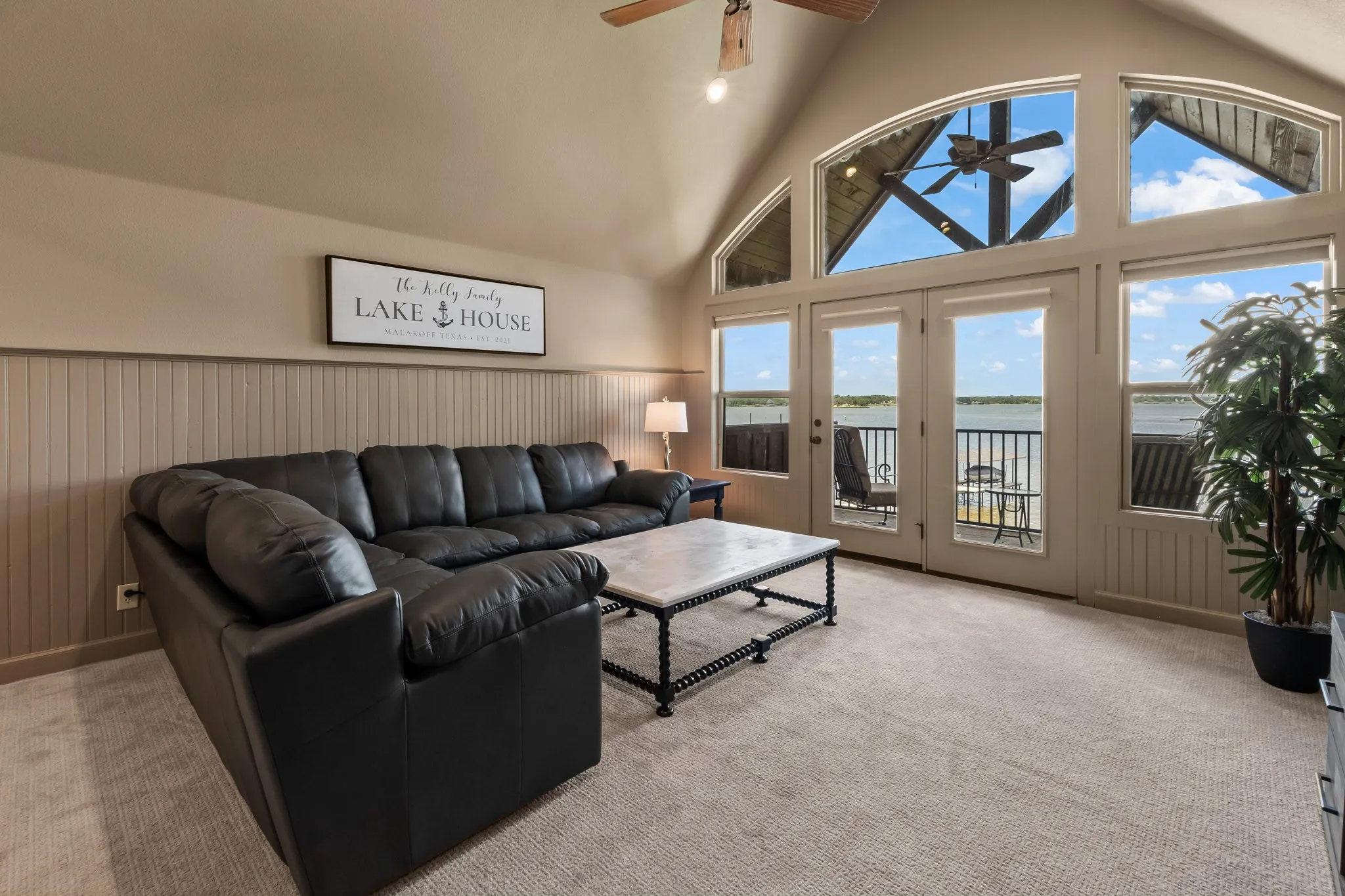 Upstairs Second Living Area with vaulted ceilings and open water views opening to the balcony.