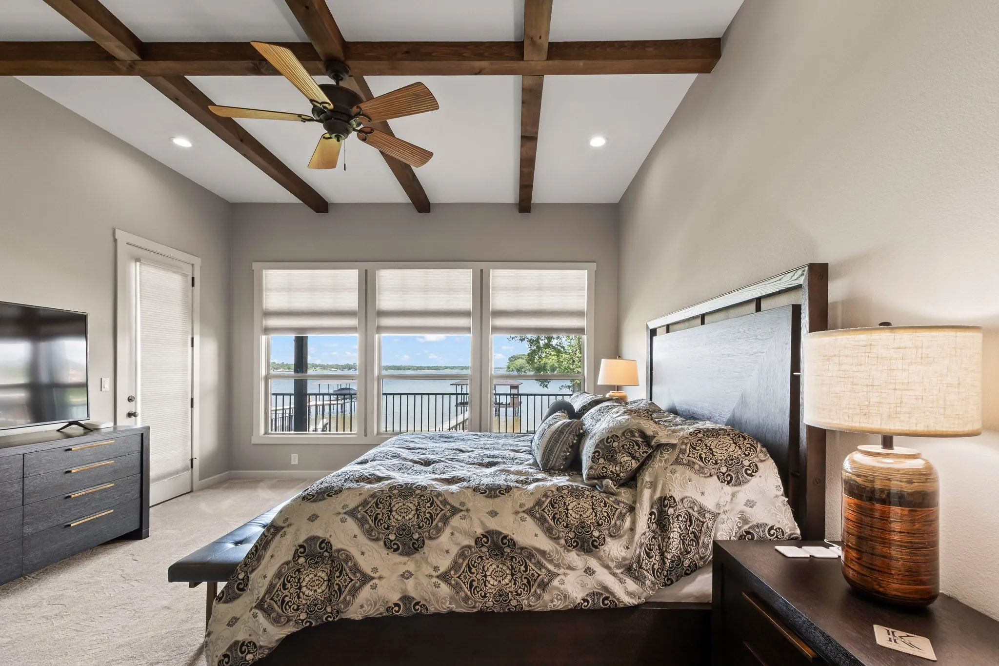 Waterside primary suite complemented by wood accents and open-water views plus private patio access.