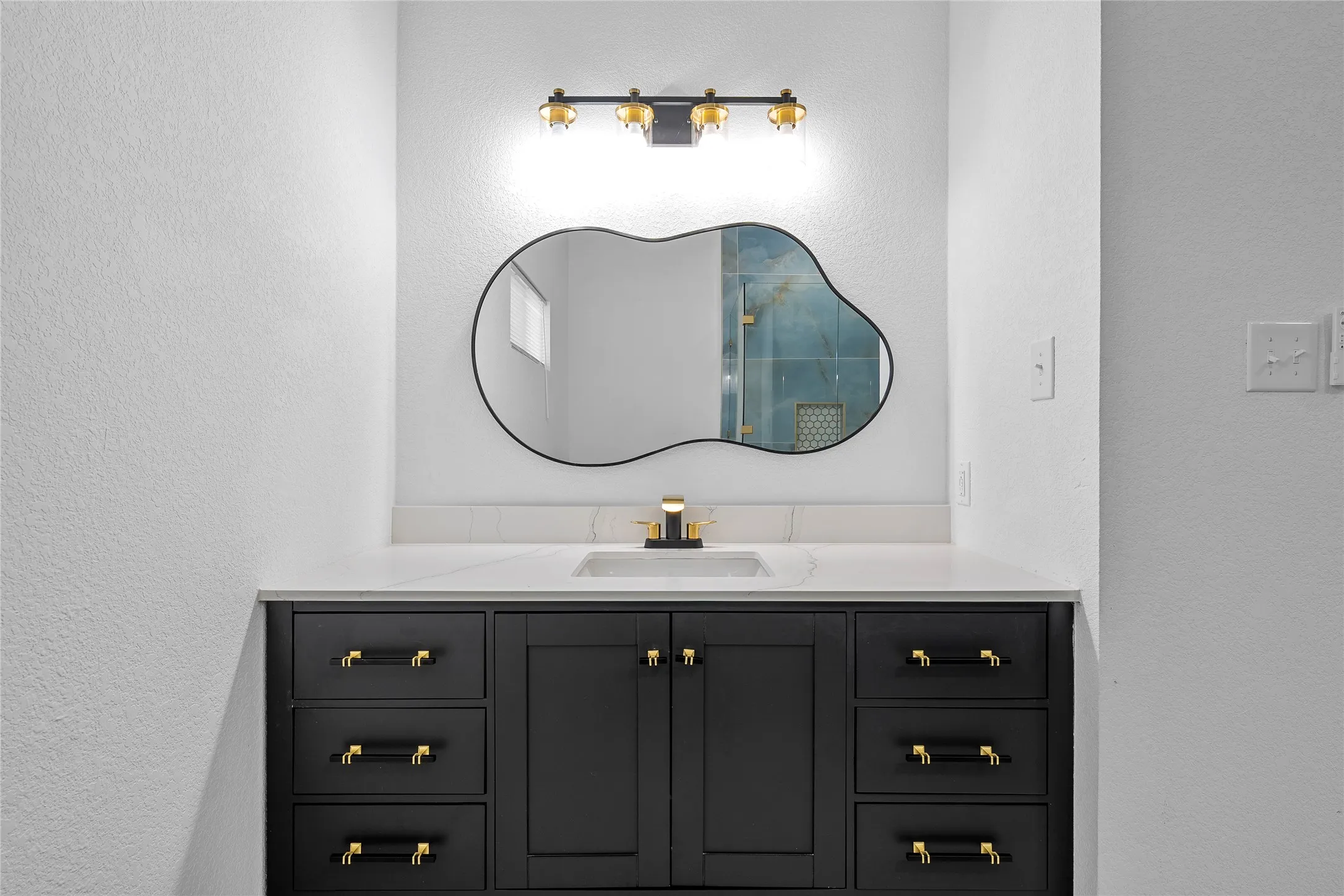 Modern vanity with a black cabinet base and gold-tone hardware