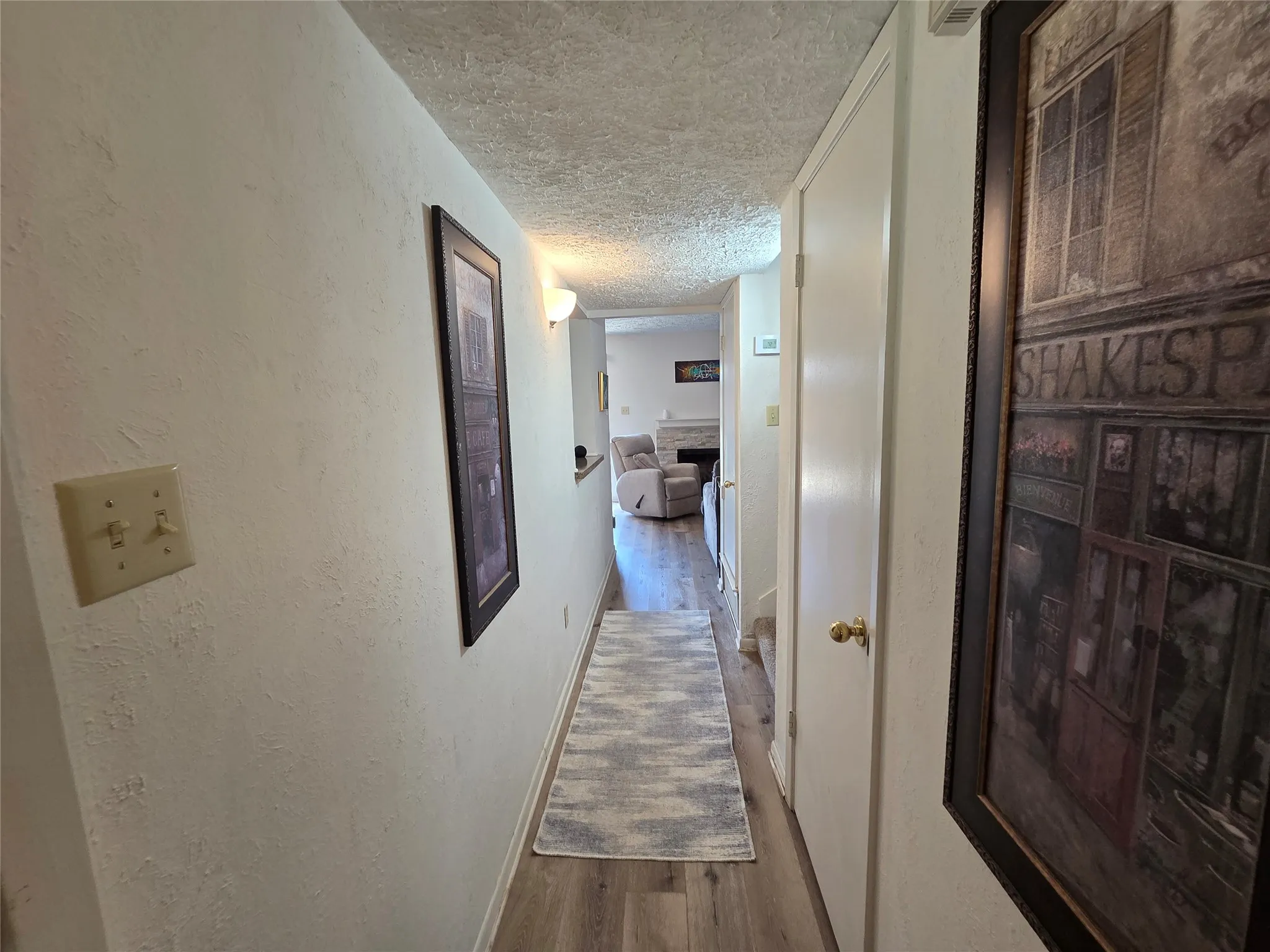 Hallway featuring wood-finish flooring and light-colored walls