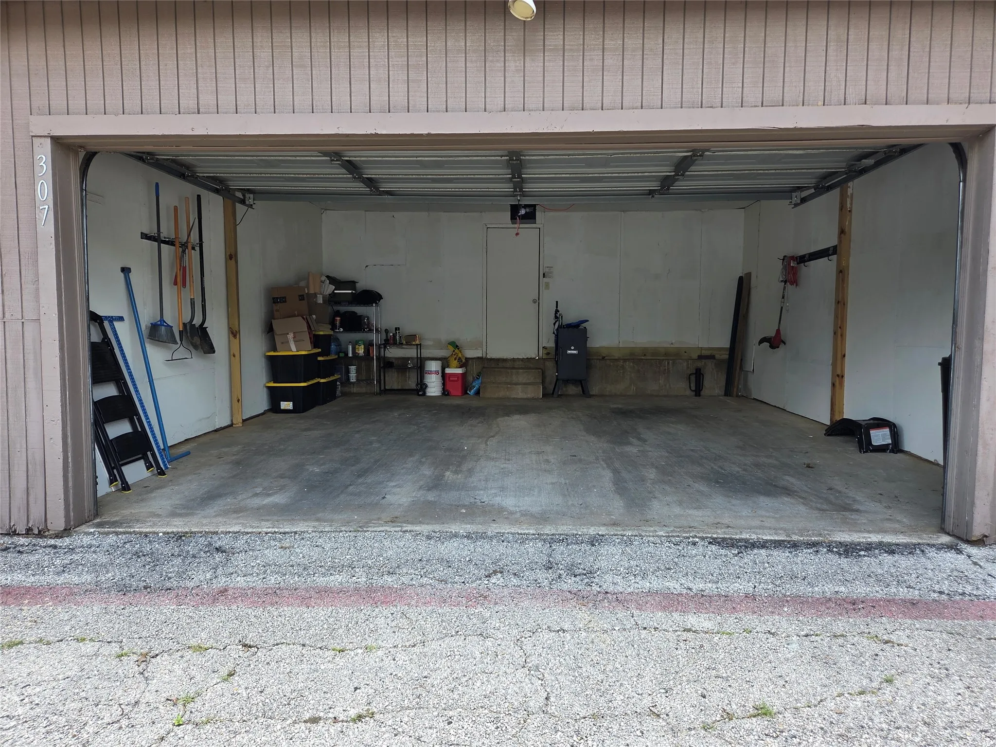Enclosed garage space with a concrete floor and white interior walls