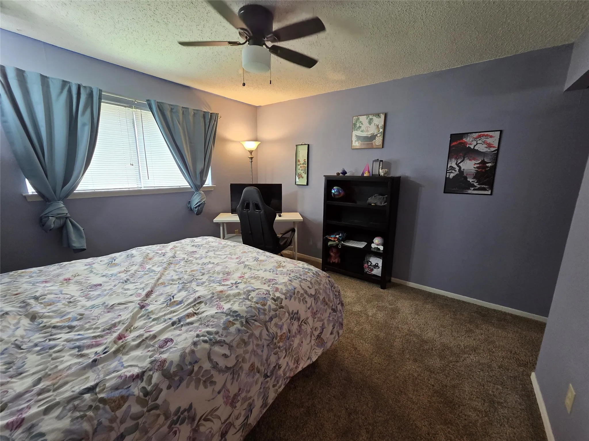 Carpeted room featuring a ceiling fan with integrated lighting, two windows with blinds, and painted walls