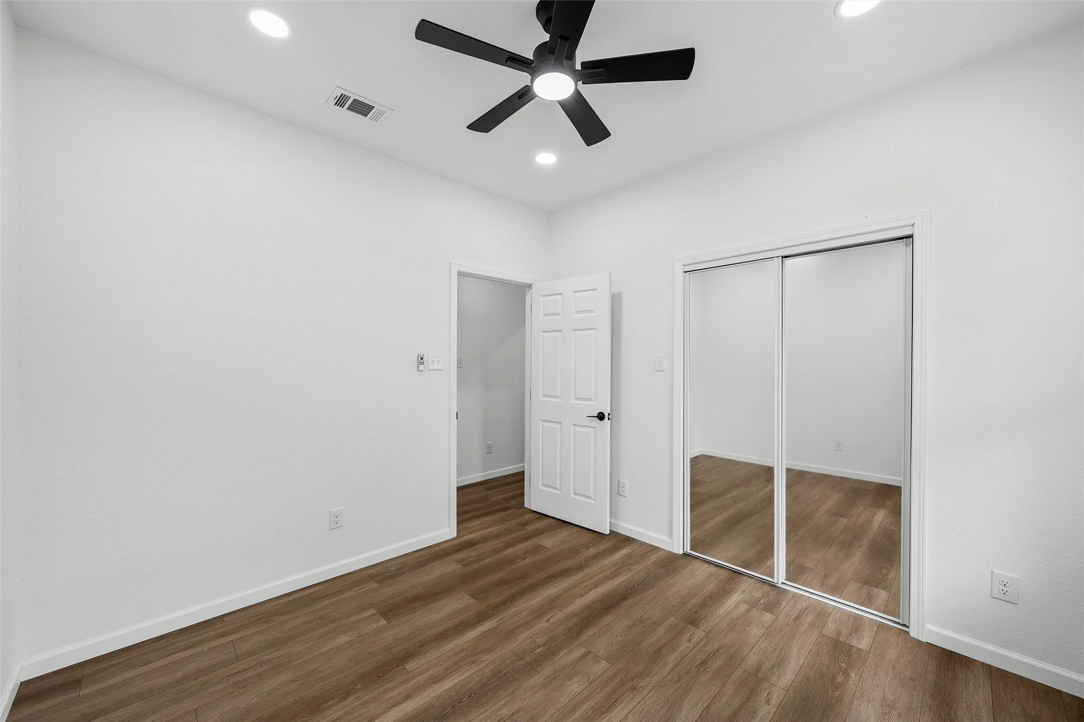 Bedroom featuring wood-finish flooring, a contemporary ceiling fan with integrated lighting, and recessed ceiling lights