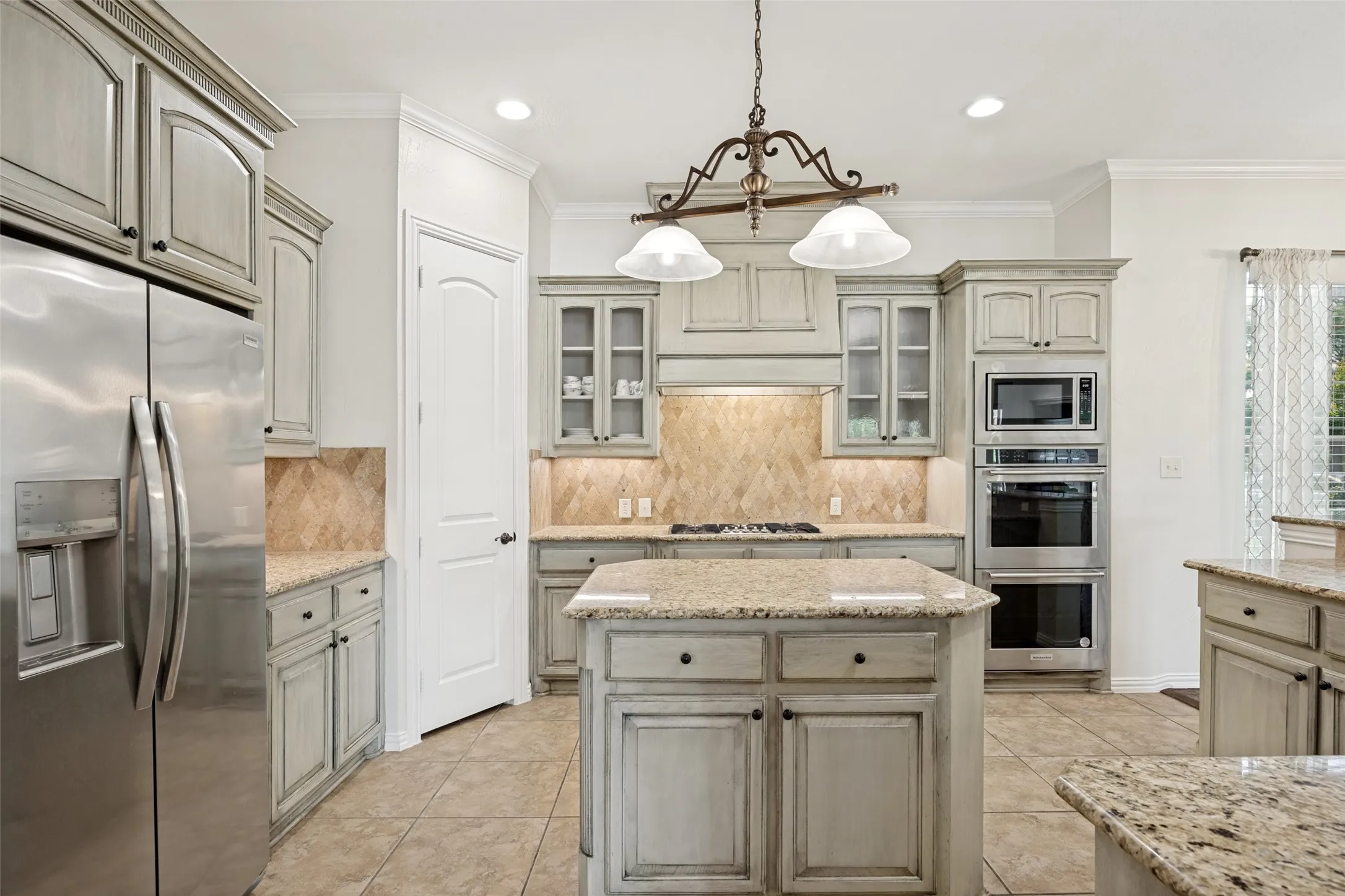 Kitchen featuring light-toned cabinetry, granite countertops, and tile flooring