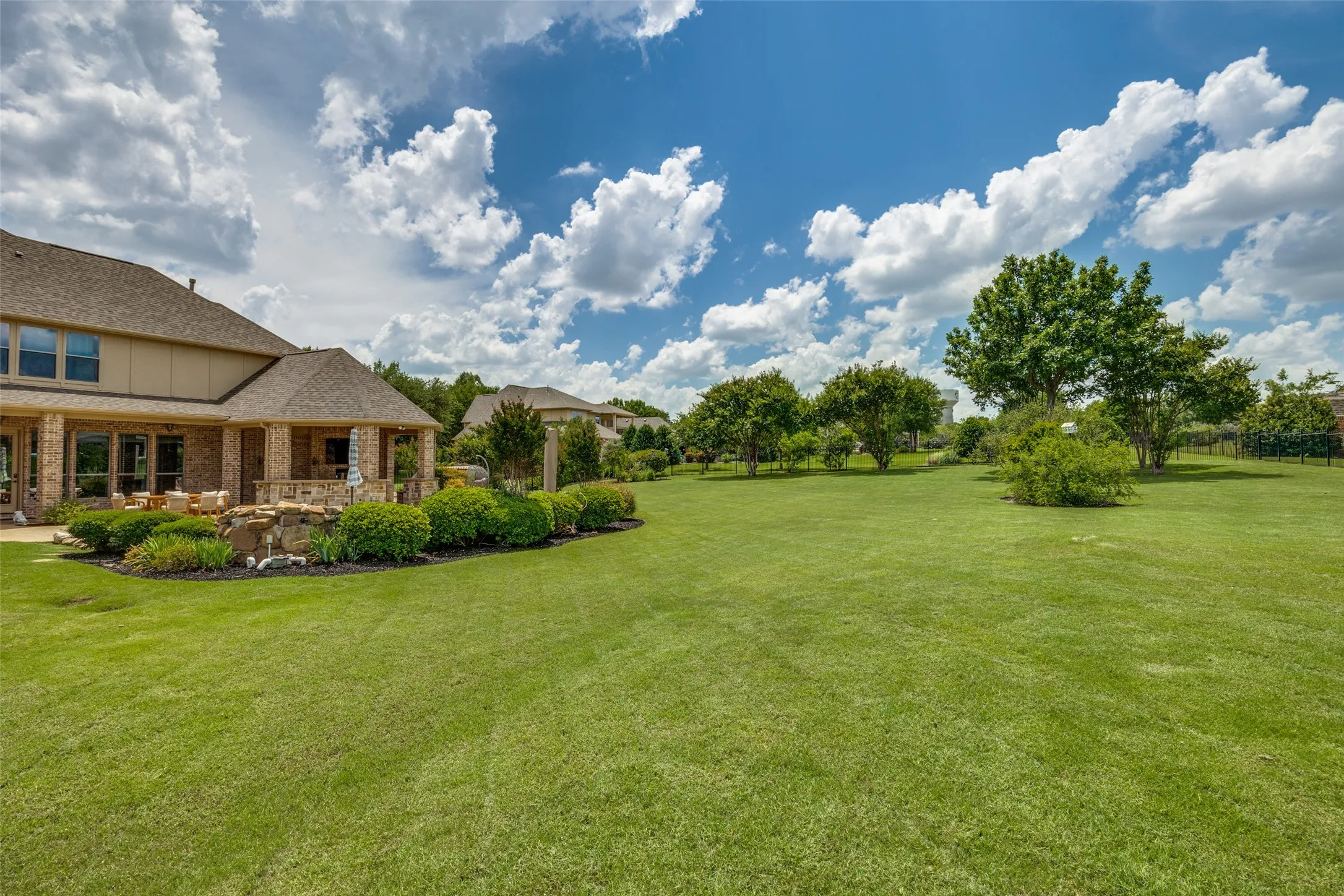Expansive green lawn with mature trees and landscaping