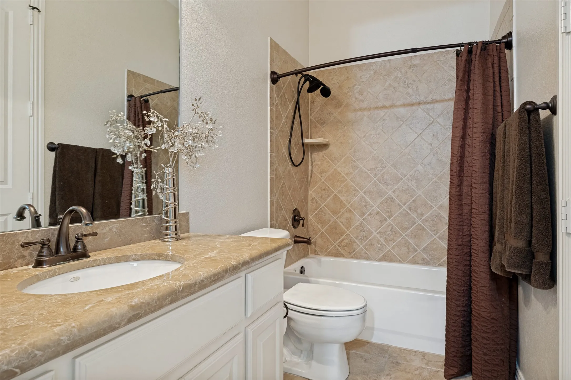Bathroom featuring a built-in vanity with a cream-toned countertop, undermount sink, and oil-rubbed bronze faucet
