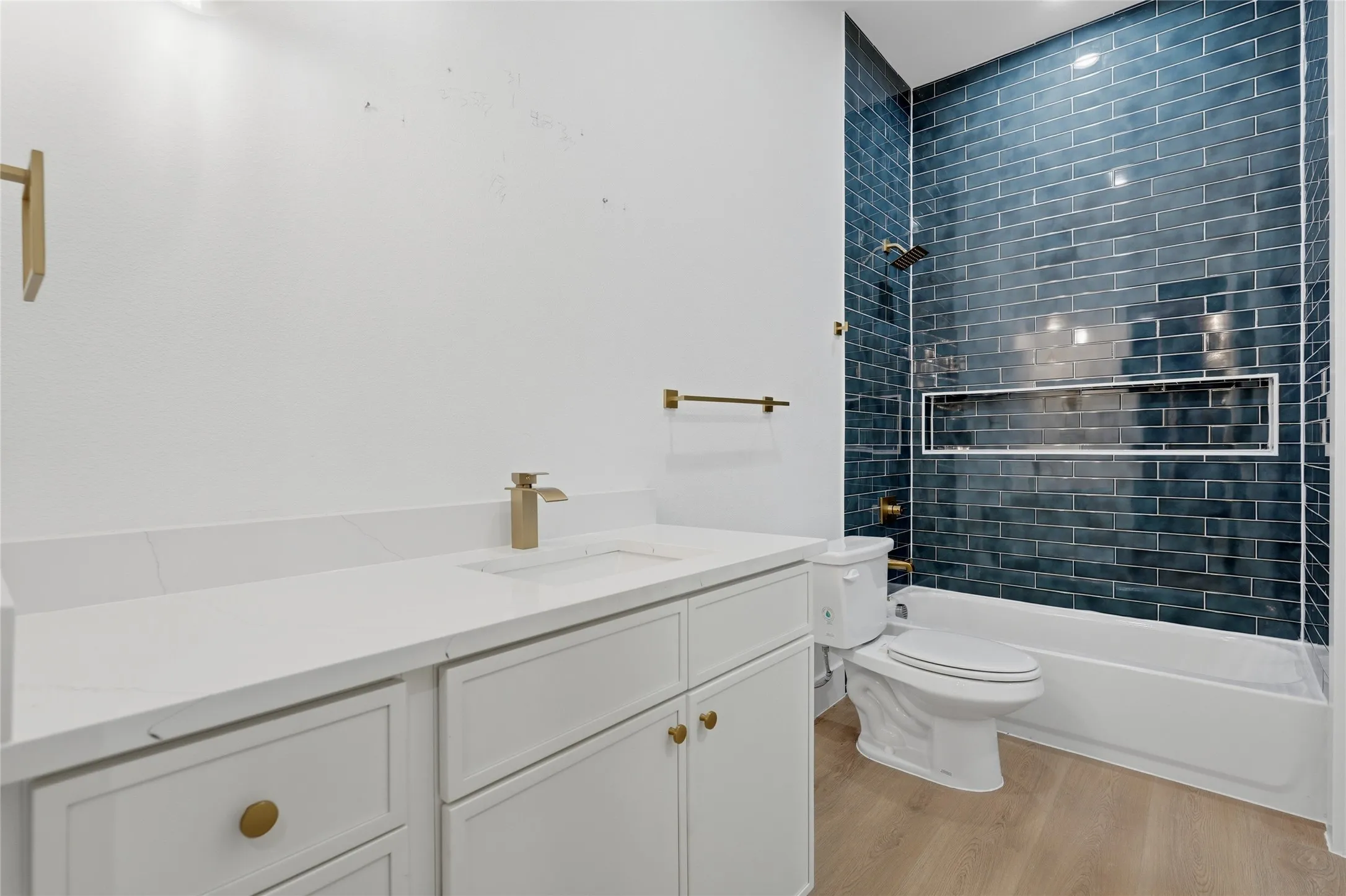 Bathroom featuring a white vanity with gold hardware, a white countertop, and a built-in sink
