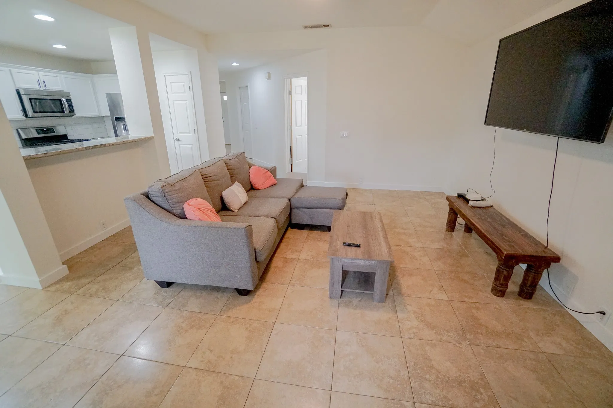 Bright living area featuring neutral-toned tile flooring throughout. 203 Grassy Creek Dr, Wylie, TX 75098