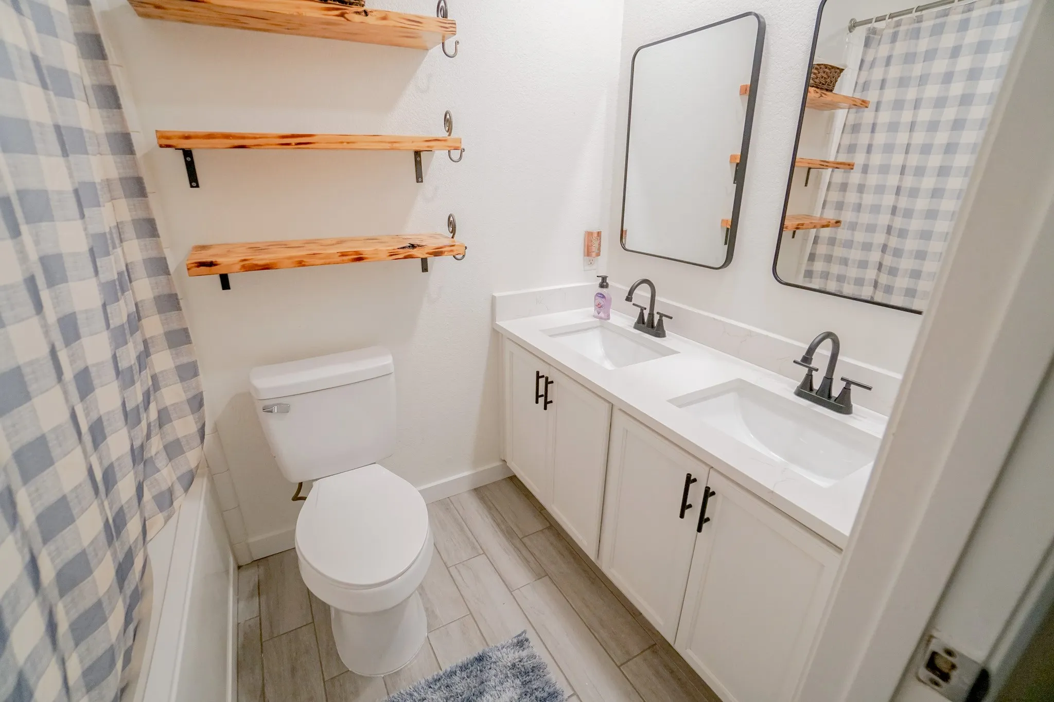 Double vanity with white cabinetry, matte black hardware, and integrated rectangular sinks