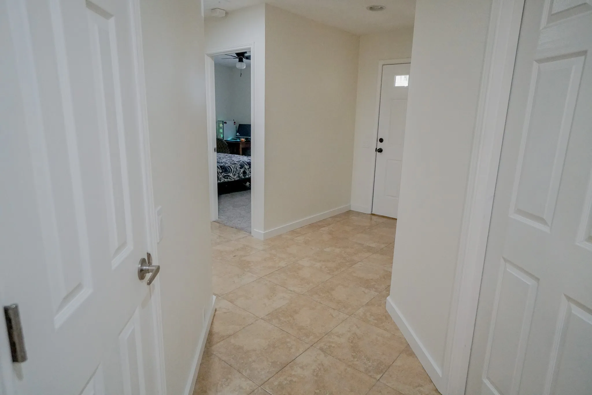 Tiled entryway featuring a panel door with a clear glass insert and a second panel door with a satin nickel handle