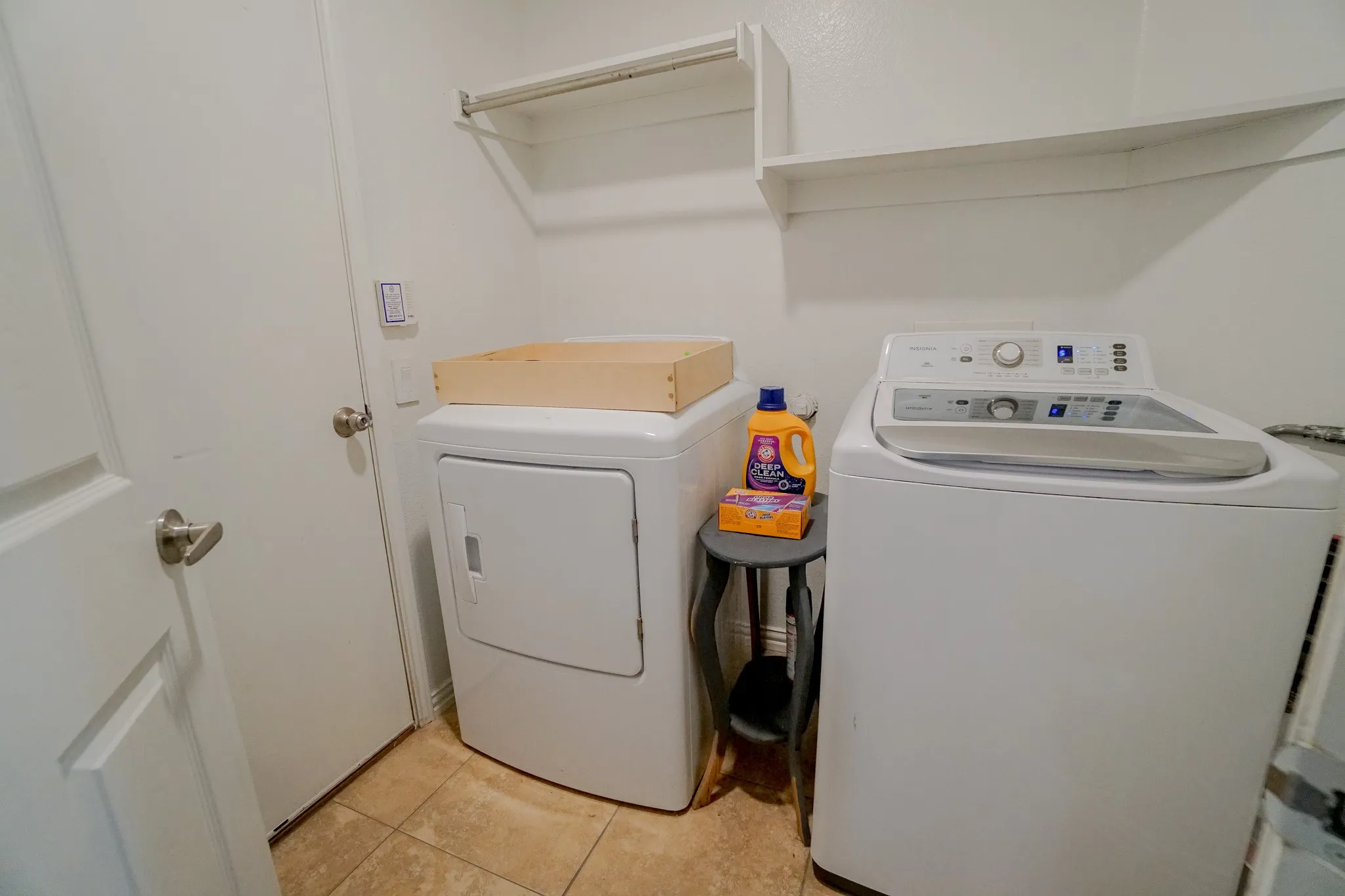 Dedicated laundry area featuring tile flooring, white walls, and built-in shelving