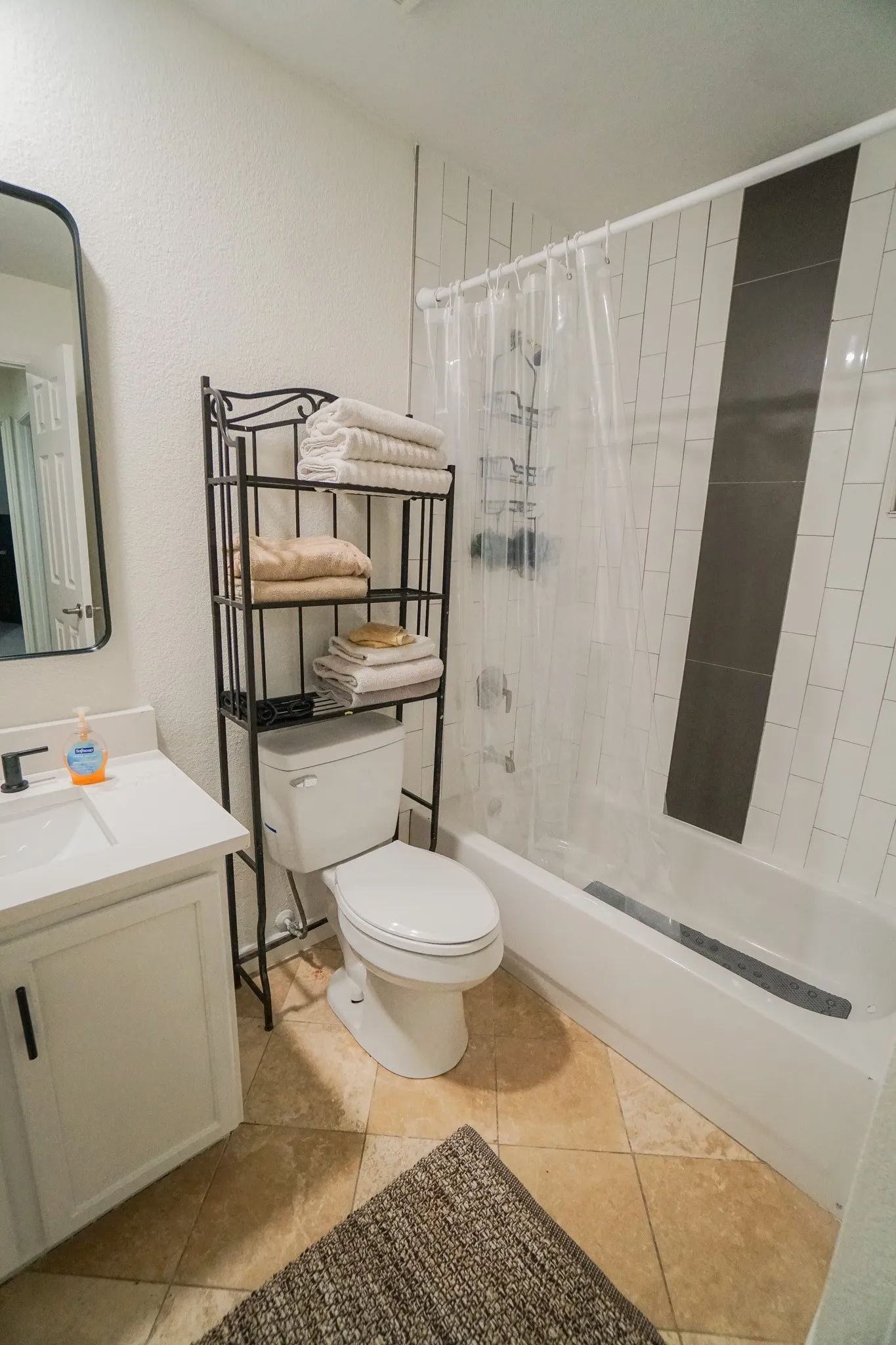 Bathroom featuring a white vanity with a single basin sink, matte black faucet, and white countertop
