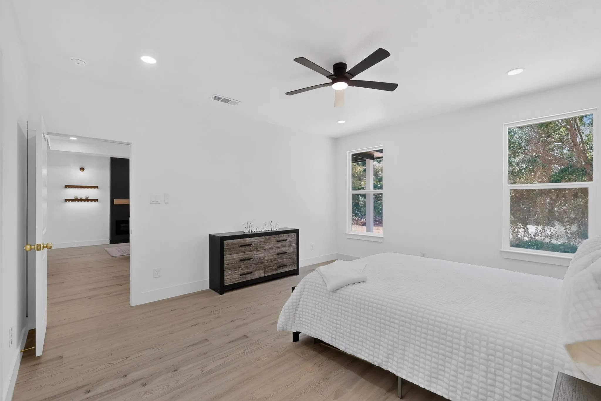 Bright room featuring wood-finish flooring, recessed lighting, and a contemporary ceiling fan