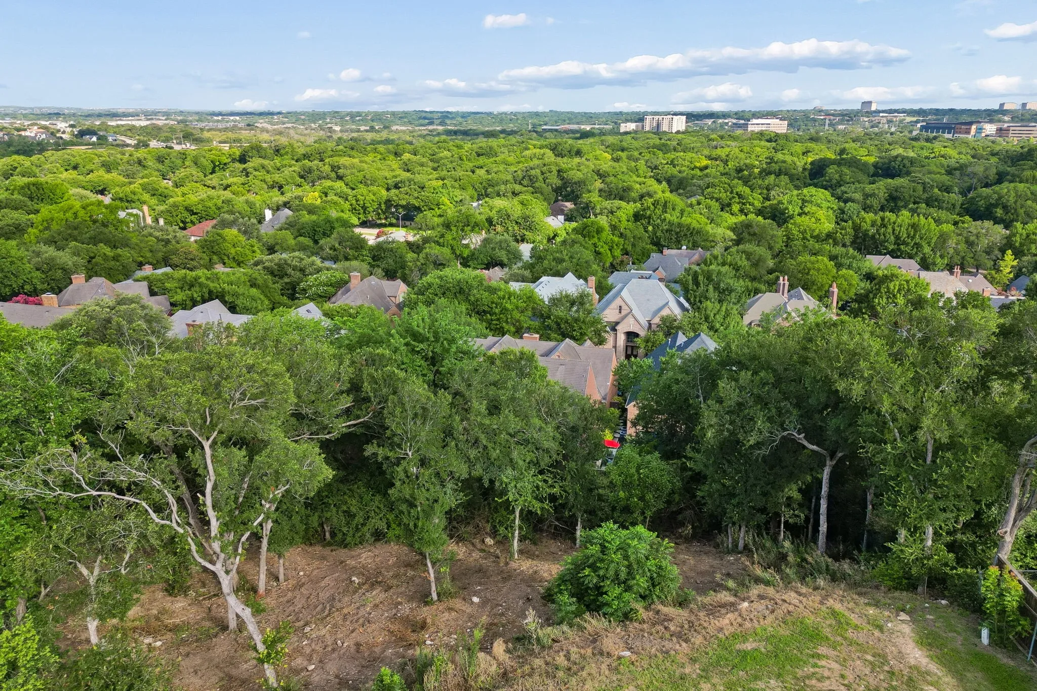 Elevated aerial view showcasing the surrounding tree canopy, established Overton West setting, and distant view corridor.