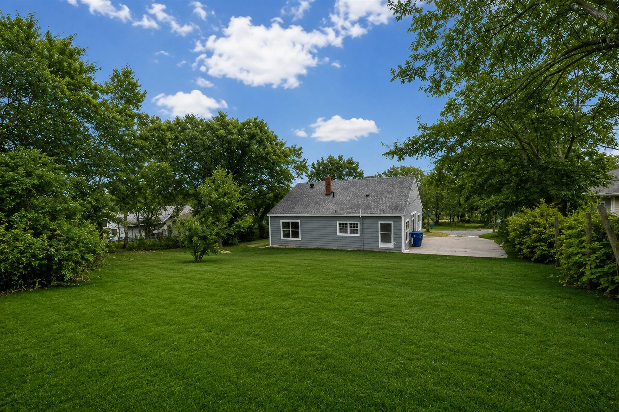 Expansive green lawn with mature perimeter trees
