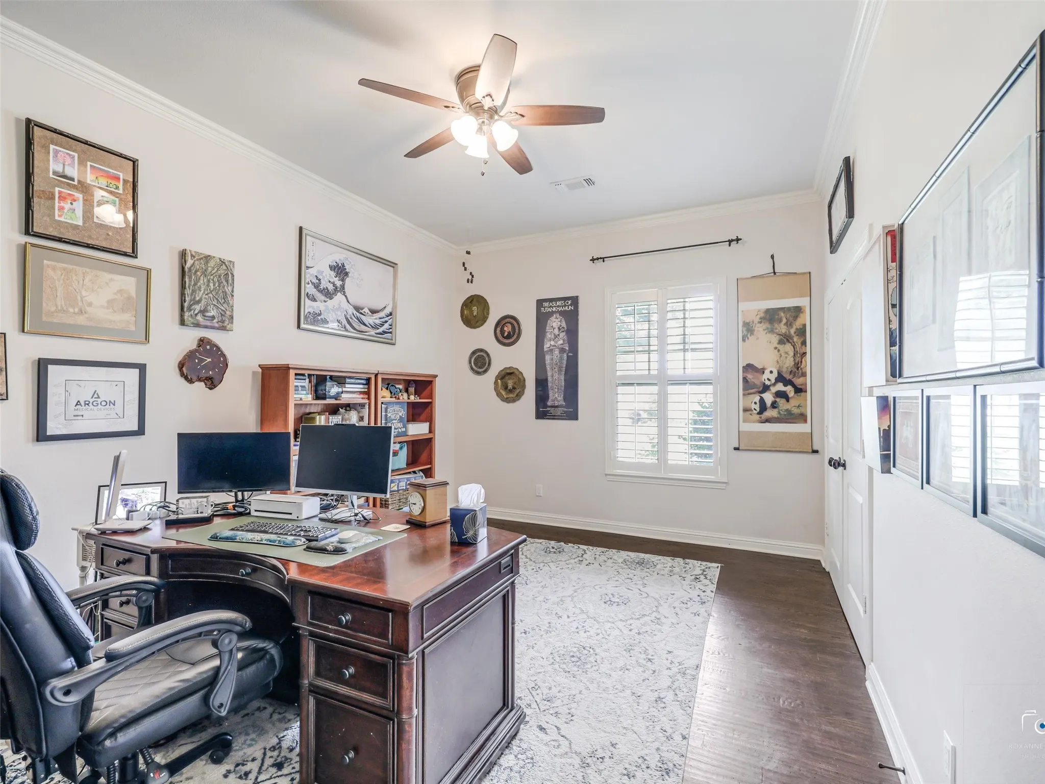 Interior room featuring dark wood-finish flooring, white walls, and a ceiling fan with integrated lighting