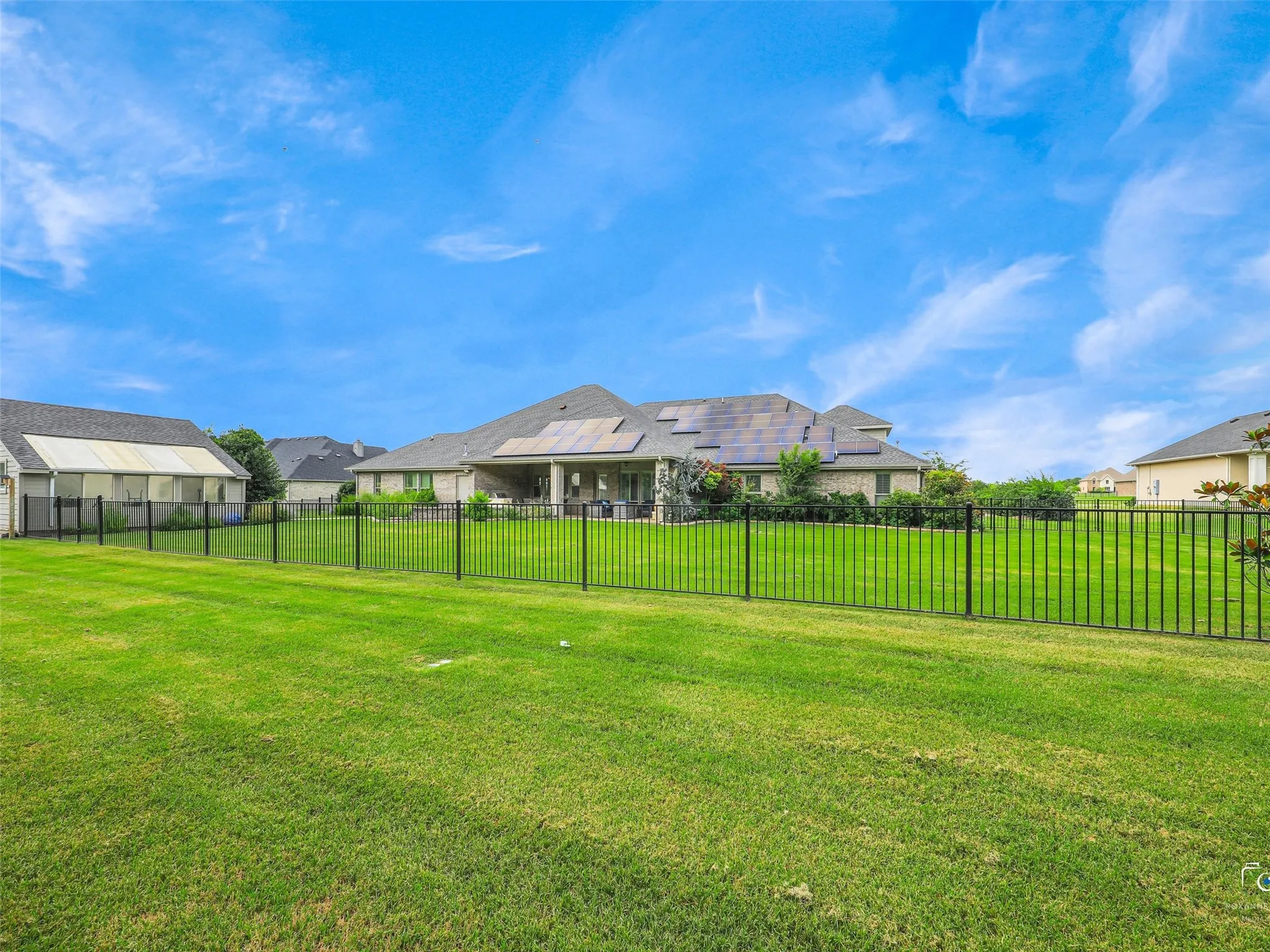 Expansive fenced backyard featuring a substantial lawn